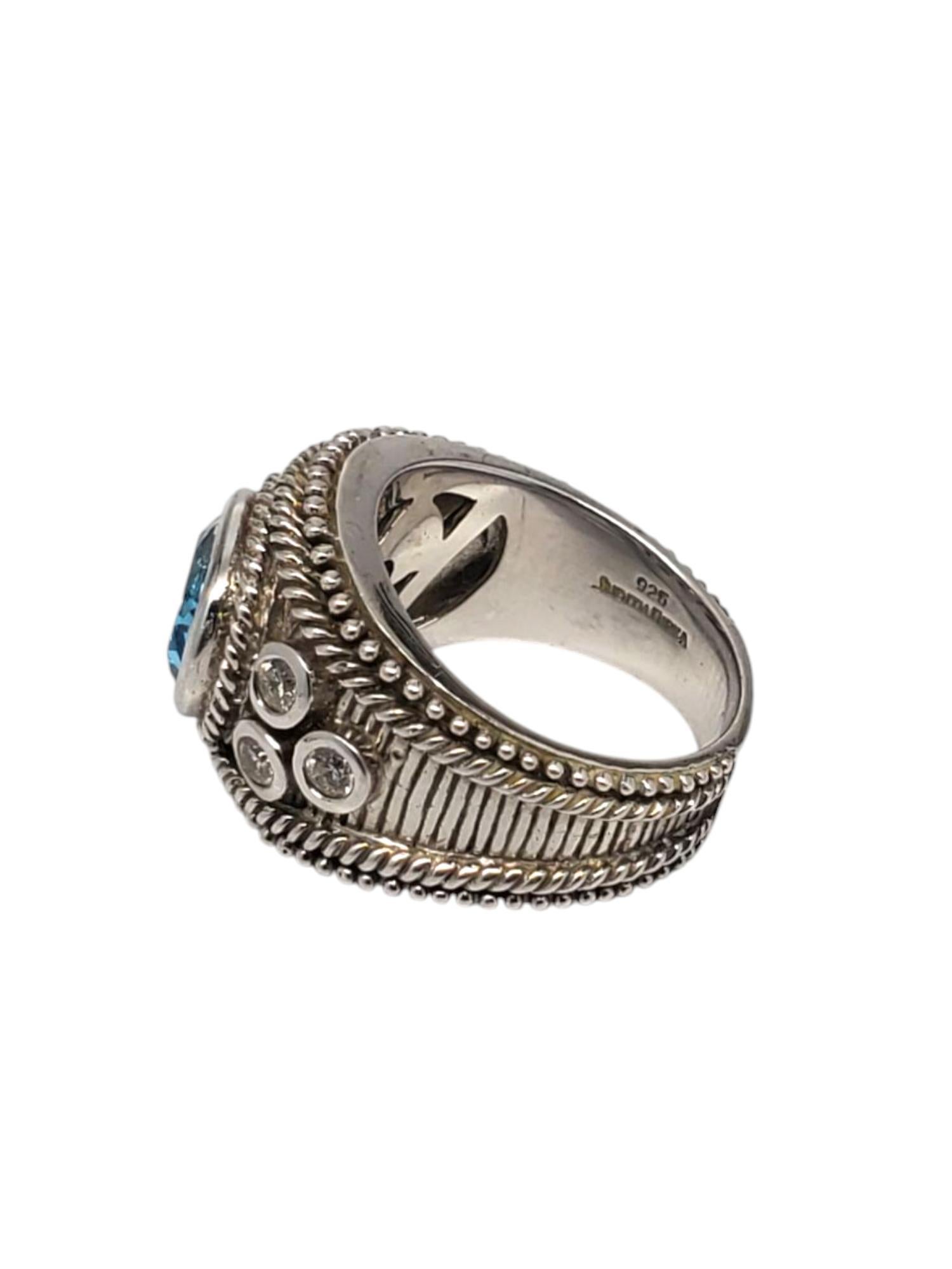 Judith Ripka Sterling Silver Blue Topaz Signet Ring 

This beautiful ring features a large faceted blue topaz gemstone (8 mm x 10 mm) and is adorned with 3 CZ on each side set in a sterling silver beaded textured design by

Shank: approx.  5.5