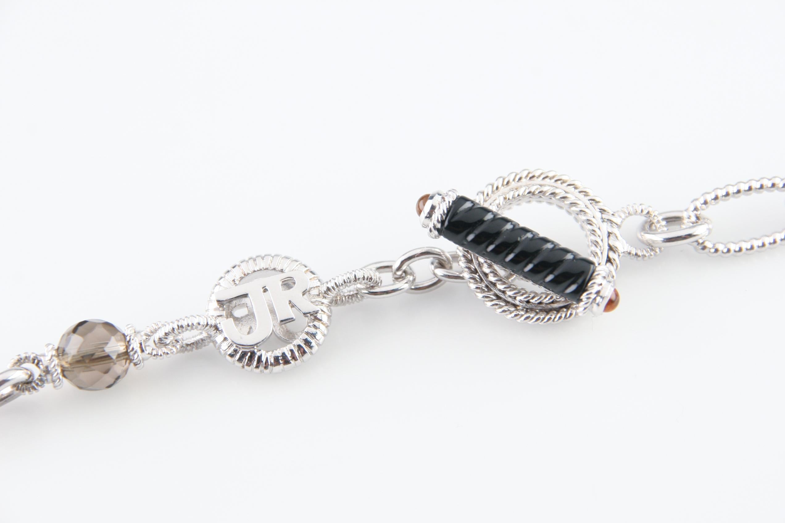 Splendida collana a catena in argento sterling di Judith Ripka, dalla texture unica.
Presenta 10 perline di quarzo fumé con taglio briolette.
Termina con una chiusura ad alamaro con accenti di onice e cabochon di topazio.
Peso: 41.7