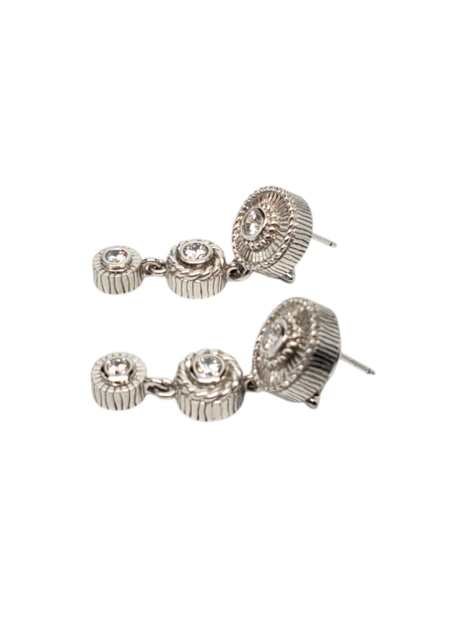 Judith Ripka Sterling Silver CZ Dangle Earrings -

These stunning pierced earrings by Judith Ripka features a 3 circle design with CZ in each and is set in classic sterling silver.

Size: 40.19 mm x 13.39 mm

Stamp: 925 JUDITH RIPKA CZ
