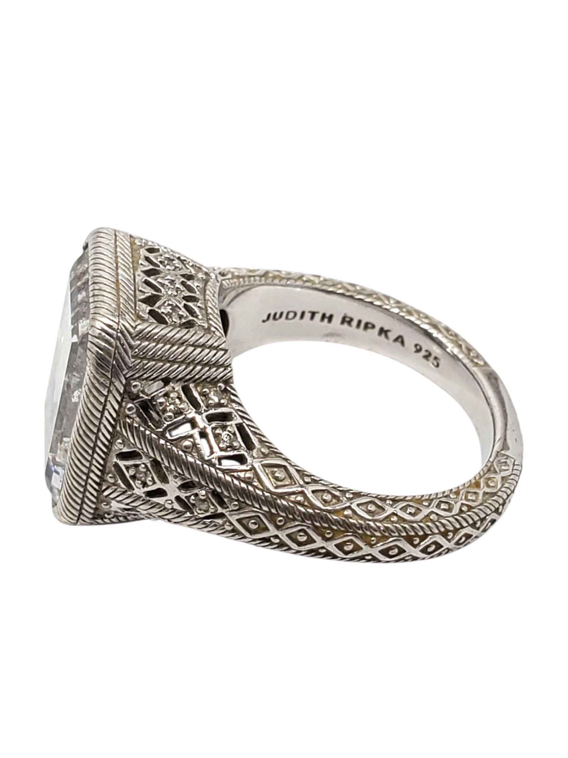 Judith Ripka Anello in argento sterling con CZ a taglio smeraldo -

Questo elegante anello di Judith Ripka è caratterizzato da una straordinaria CZ taglio smeraldo (16,23 mm x 11,58 mm} incastonata in un design a corda e filigrana in argento