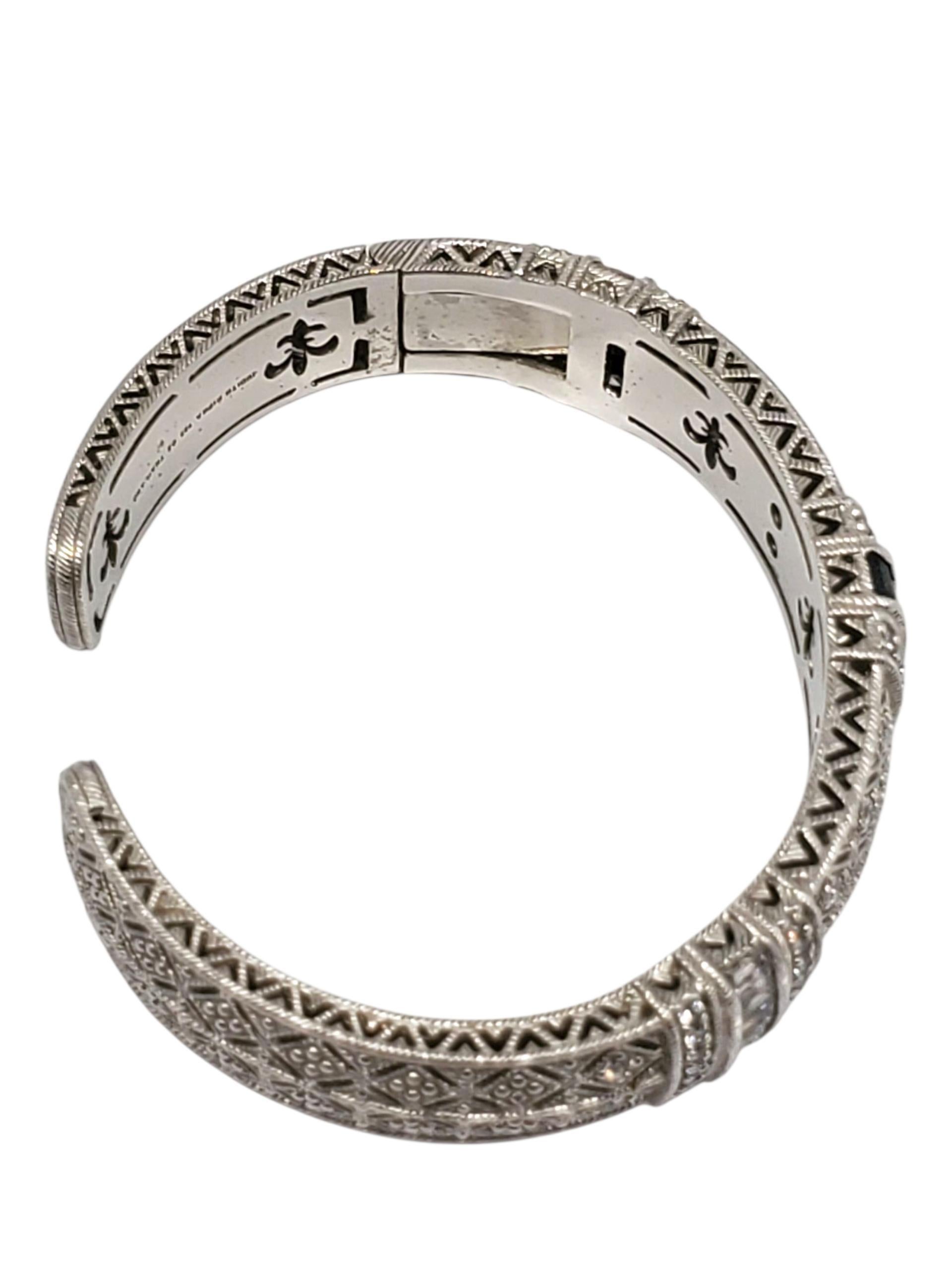 Bracciale con cerniera in argento 925 di Judith Ripka -

Questo splendido bracciale a cerniera in argento sterling di Judith Ripka presenta una fascia di pietre blu con taglio a baguette, accentate da CZ trasparenti, in un design strutturato e a