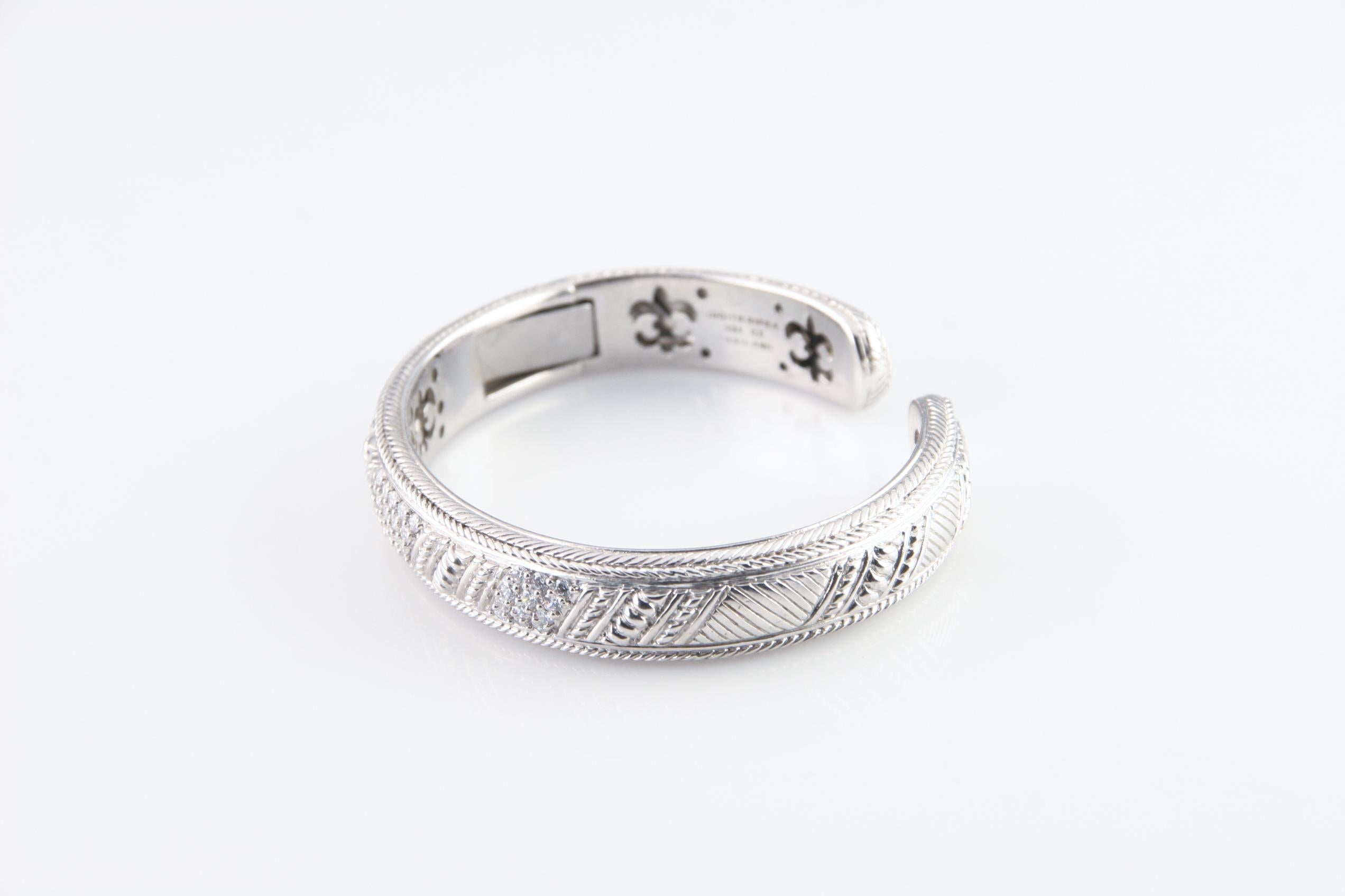 Splendido bracciale a cerniera in argento massiccio di Judith Ripka.
File di diamoniques (zirconi) tondi taglio brillante incastonati a pavé.
Misura del polso: 7 pollici.
Circonferenza esterna: 8.75 pollici.
Larghezza: 12 mm.
Peso 52,7