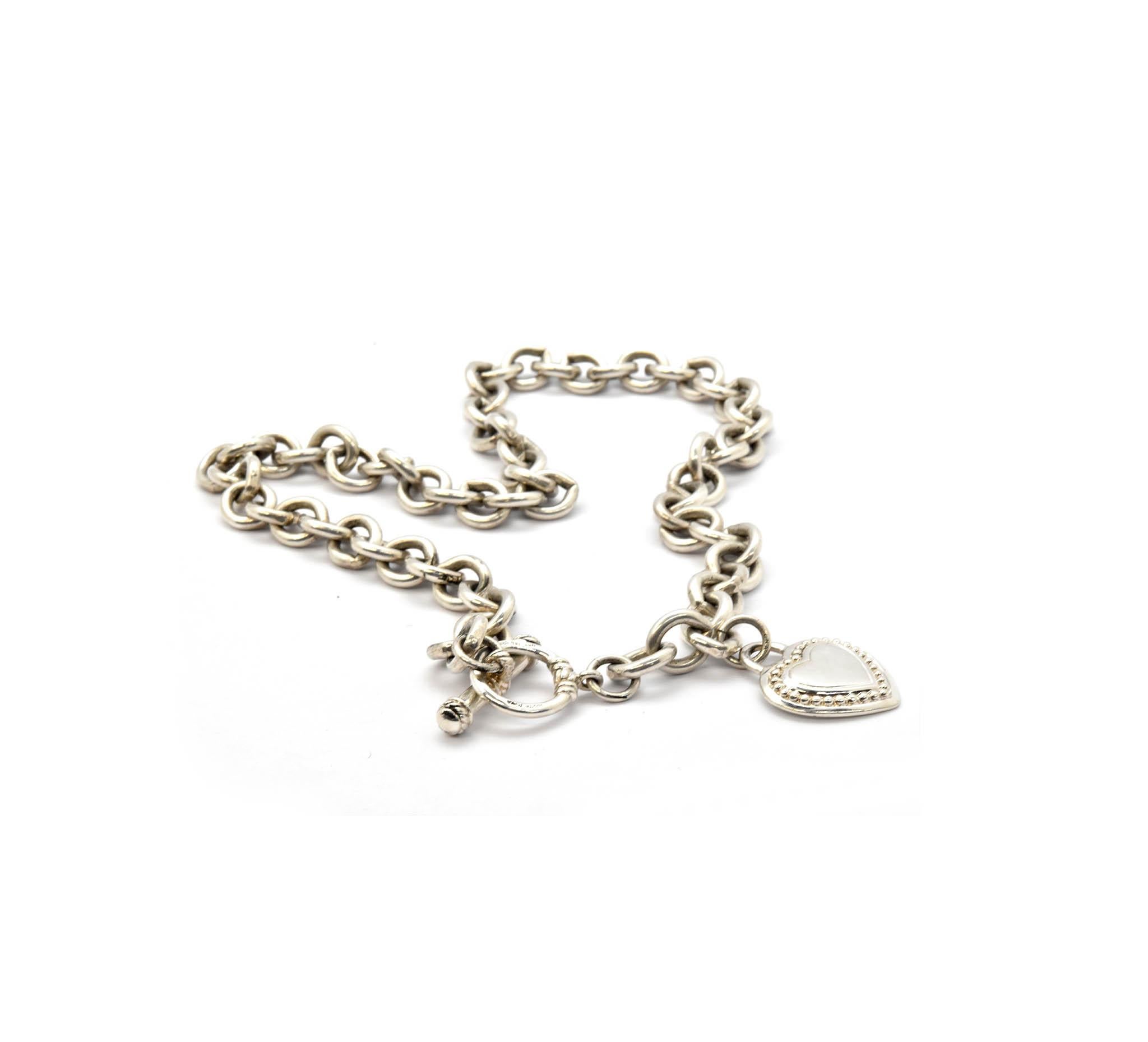 This is a Judith Ripka sterling silver chain necklace with a heart charm. The necklace consists of 20” inches of sterling silver oval shaped links with a toggle closure. The Judith Ripka heart charm measures 28x23.5mm. Classic Judith Ripka cable