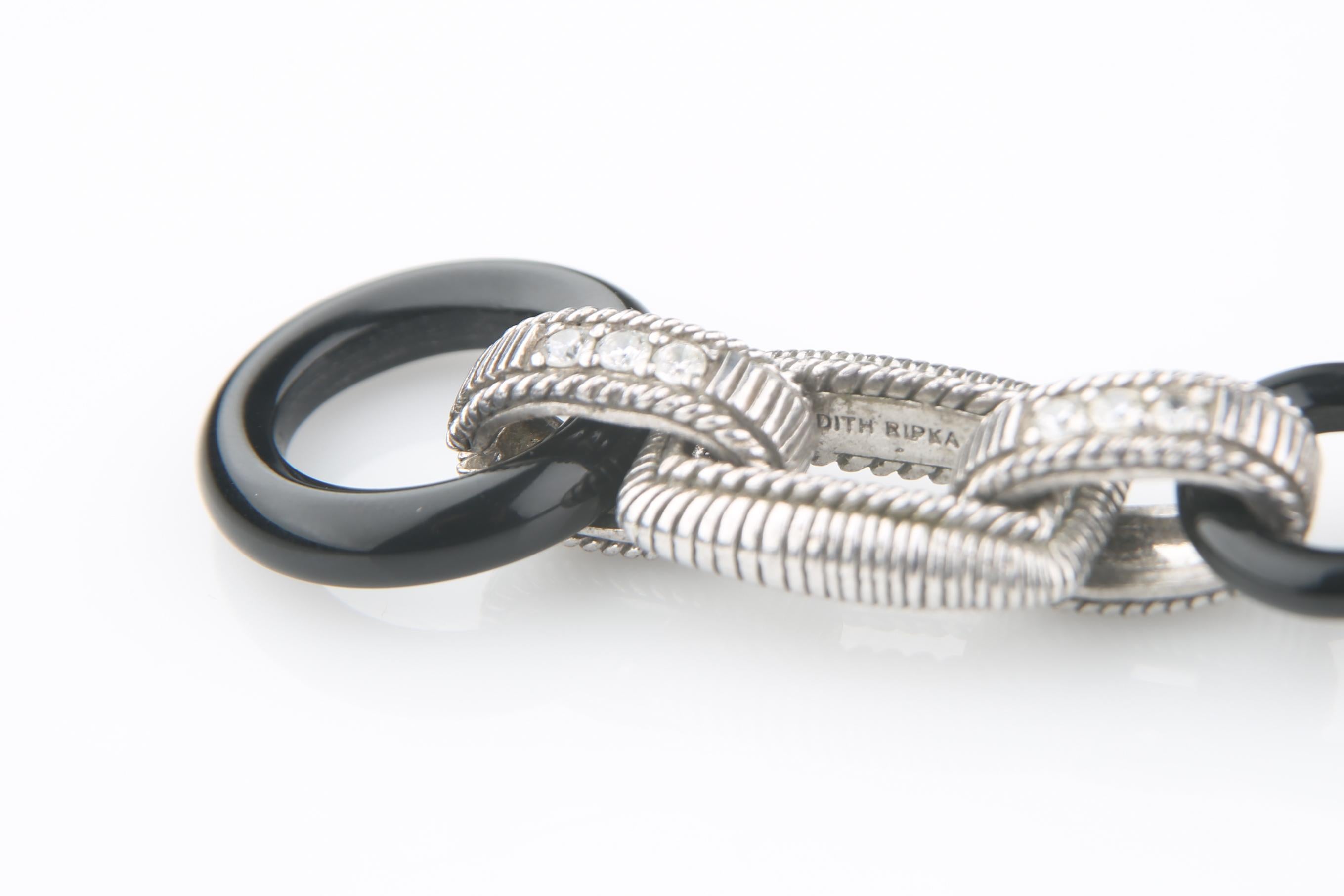 Bellissimo bracciale a maglie in argento sterling Judith Ripka
Cinque pezzi rettangolari in argento collegati a quattro anelli di onice con cerchi impreziositi da zirconi.
La chiusura a ginocchiera presenta un cerchio di onice con un cabochon di