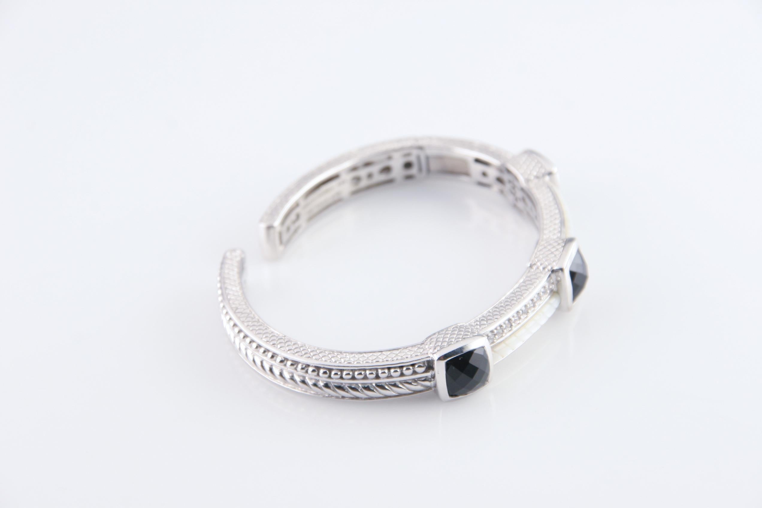 Gorgeous sterling silver cuff bracelet featuring
three bezel-set cushion cut onyx.
Two alternative rows of pavé-set cubic zirconia & custom cut mother-of-pearl.
Wrist Fit: 6.5 inches.
Outer Circumference: 8 inches.
Width: 7 mm.
Weight: 43.1