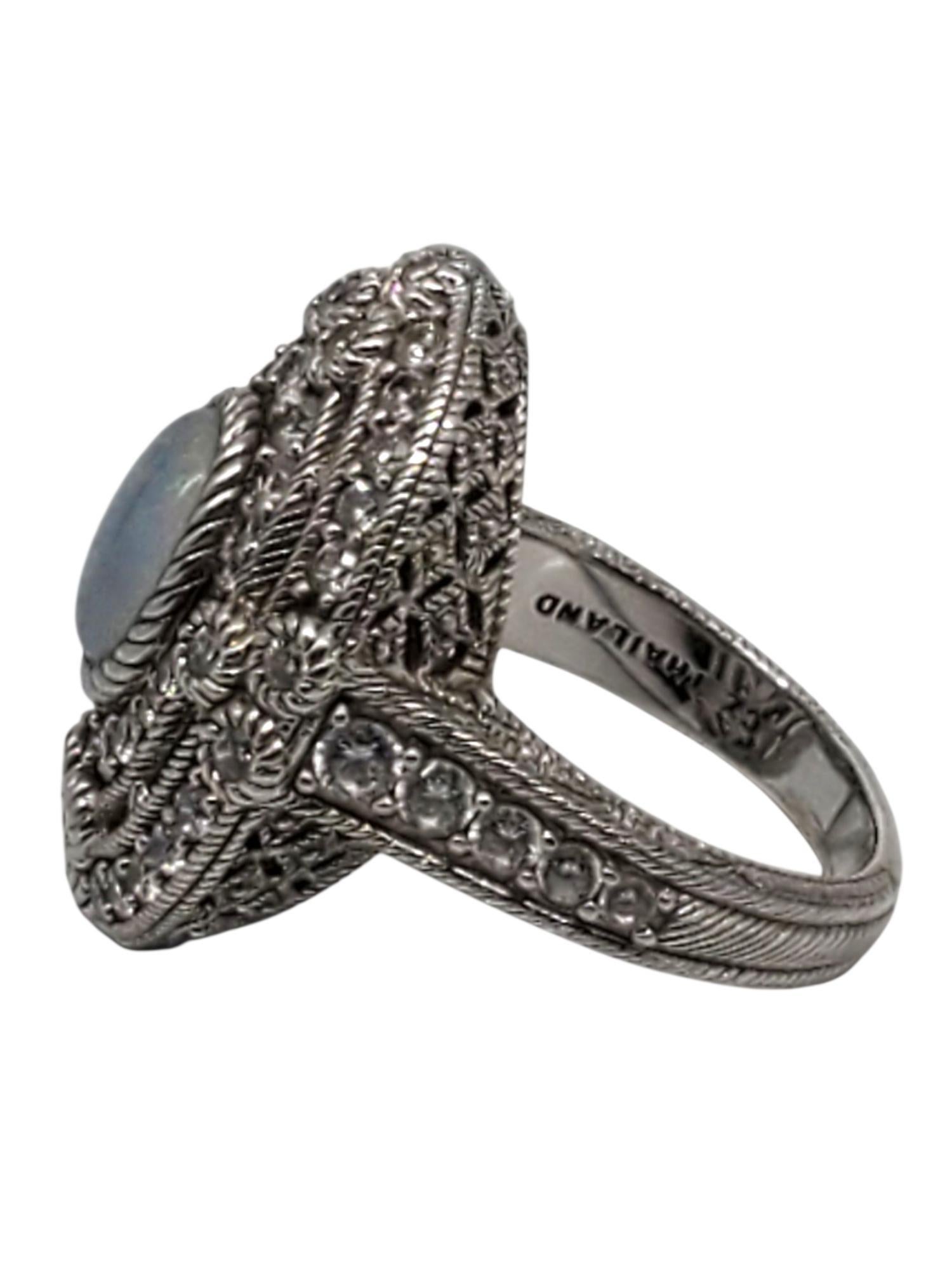 Judith Ripka Anello Cocktail in argento sterling con pietre opalescenti e cristalli -

Questo sorprendente anello da cocktail di Judth Ripka presenta una pietra opalescente ovale (15,4 mm x 7,6 mm) circondata da CZ incastonati in argento sterling