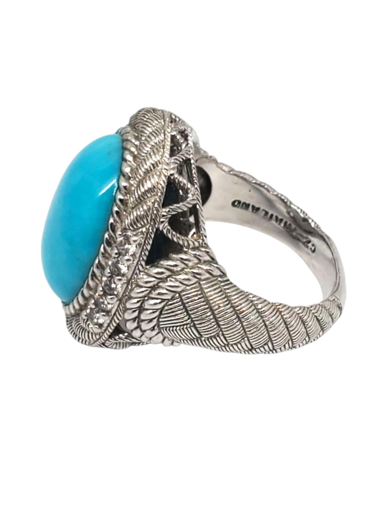 Judith Ripka Sterling Silver Turquoise & CZ Ring -

This lovely ring features a textured rope sterling silver setting with a large turquoise cabochon gemstone (16.97 mm x 12.47 mm) with CZ accents by Judith Ripka.

Shank: 3.7 mm

Size: 7

Stamped: