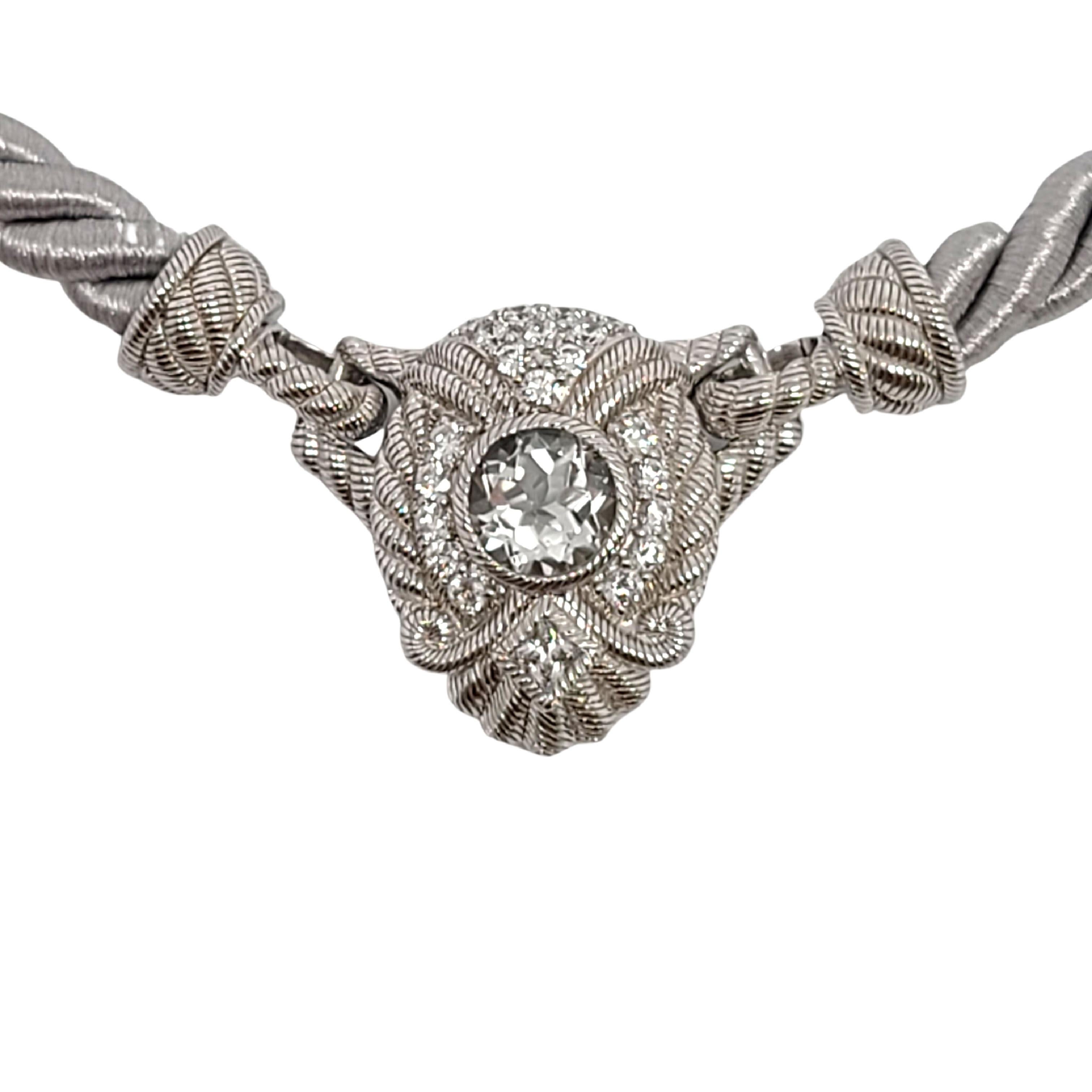 Sterling silver White Topaz and CZ enhancer on a gray silk cord by designer Judith Ripka.

This beautiful piece features sterling silver textured enhancer with a large round faceted white topaz and small round CZs. The gray silver rope design cord