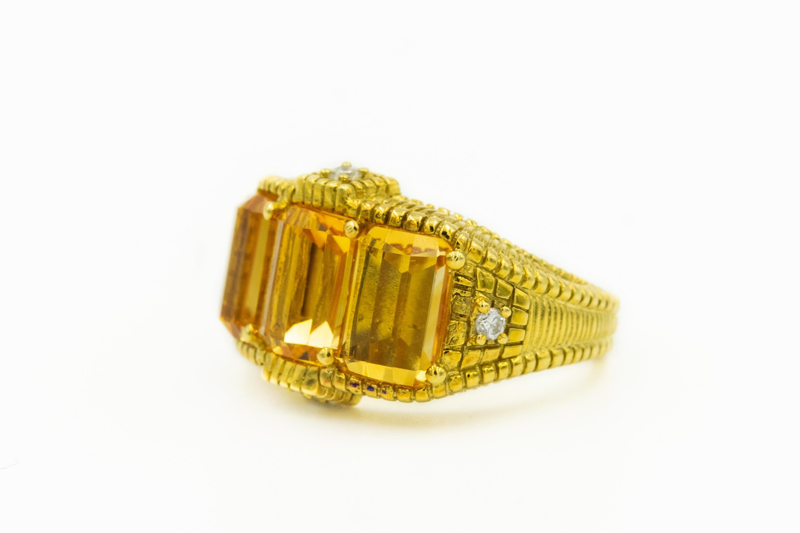 Judith Ripka cocktail ring featuring three emerald cut citrines and four small round brilliant diamonds accents mounted in an 18k yellow gold highly stylized textured mounting.

US size 7.5.

Marked Judith Ripka 18k
