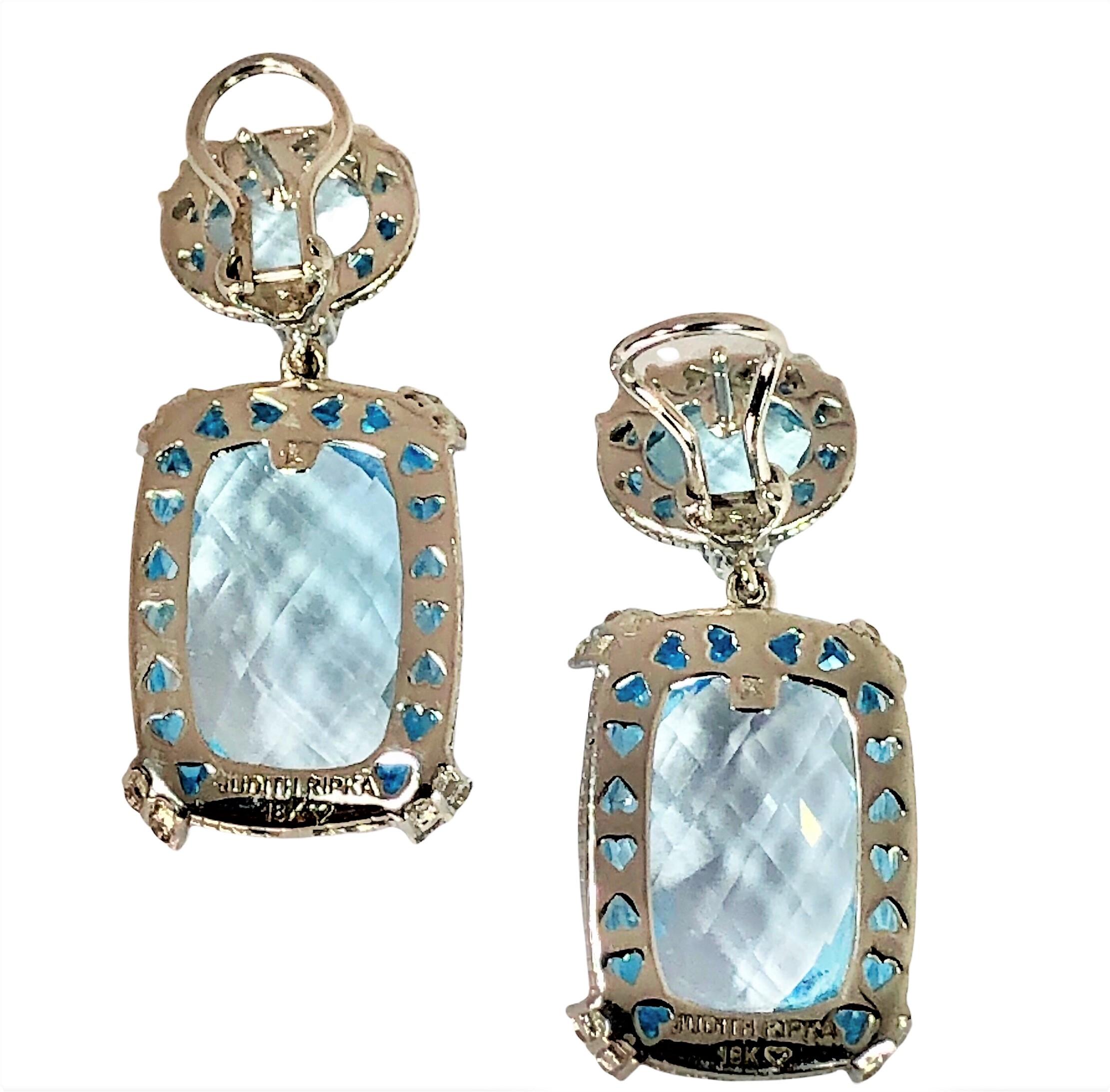 This is a truly stunning pair of 18k white gold, diamond and blue topaz earrings by Judith Ripka. Each earring is set with one checkerboard faceted natural blue topaz cushion shaped briolette and one oval shaped blue topaz briolette faceted in the