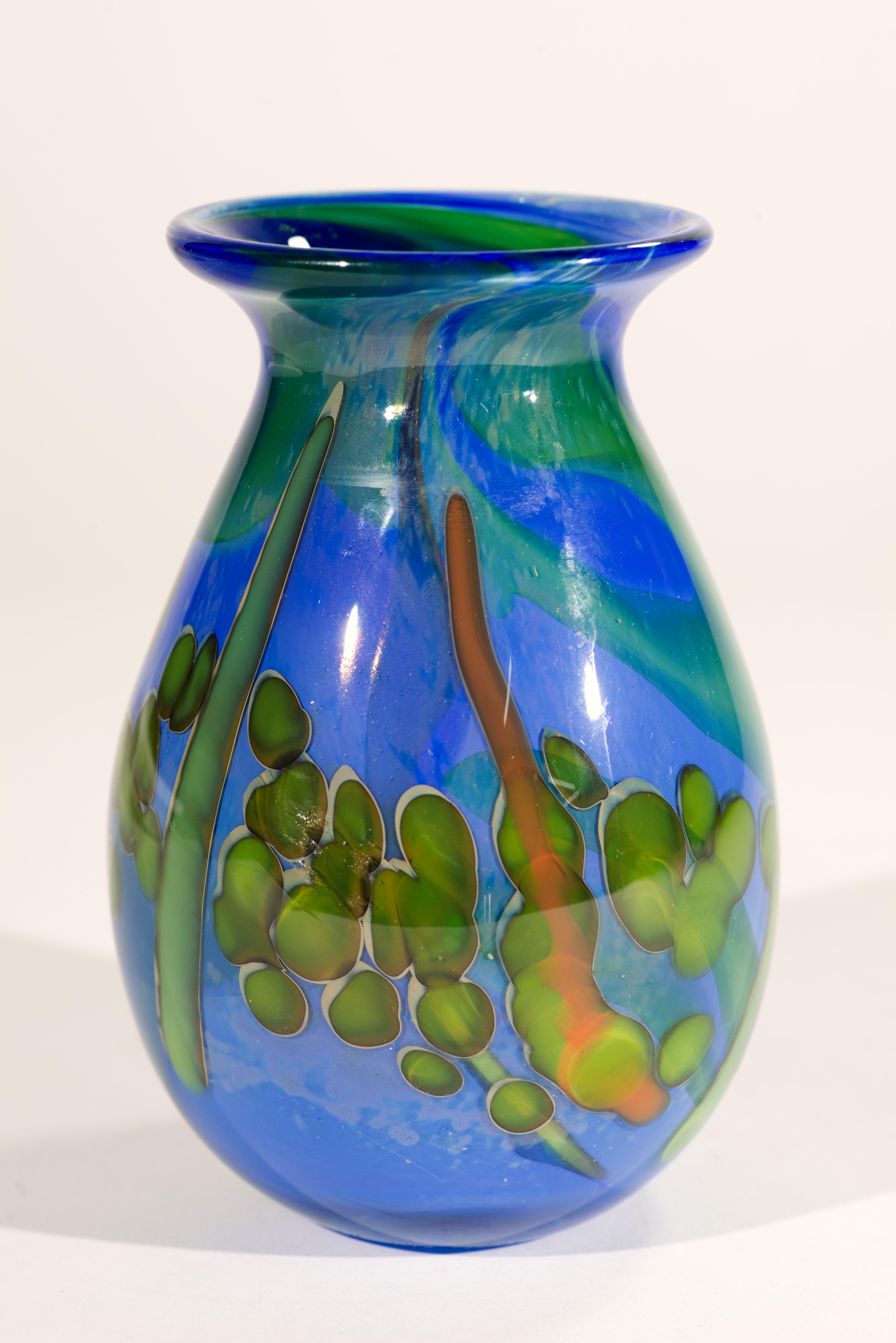 Il vaso di gemme in vetro artistico vintage è stato soffiato a mano con un motivo astratto a più strati di inclusioni di vetro murino verde e arancione sullo sfondo di vetro blu. Il nucleo in vetro colorato è racchiuso in vetro trasparente con la