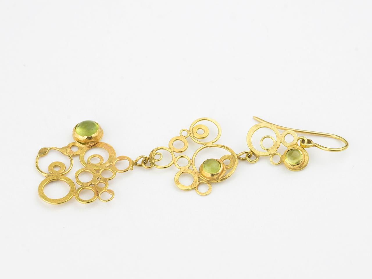 18k gold earpendants in a multi circle design with bezel set peridots.