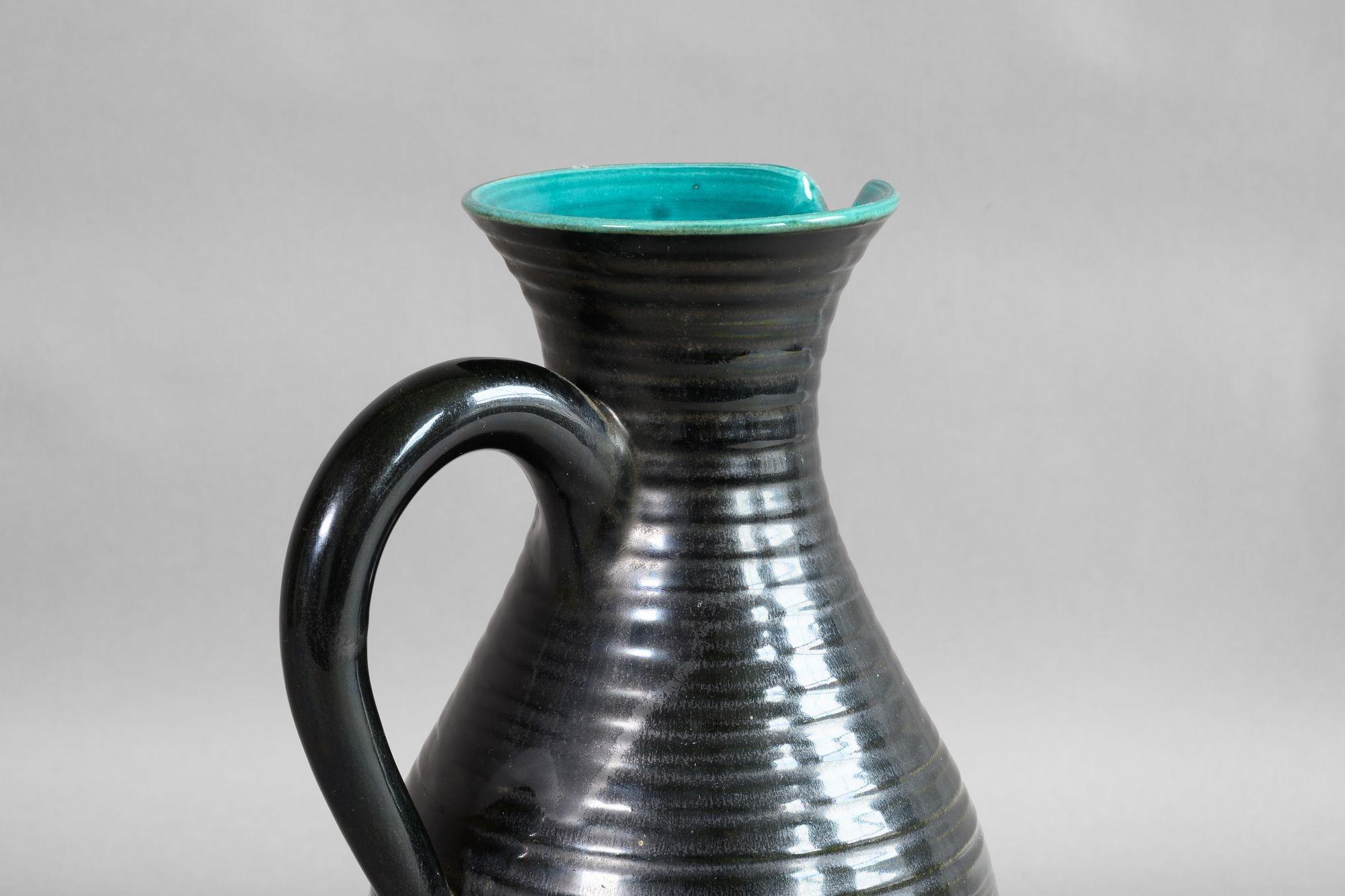 Schwarz glasierter Tonkrug mit blauer Innenglasur. CIRCA 1950

H 29cm x B 20cm x T 16cm