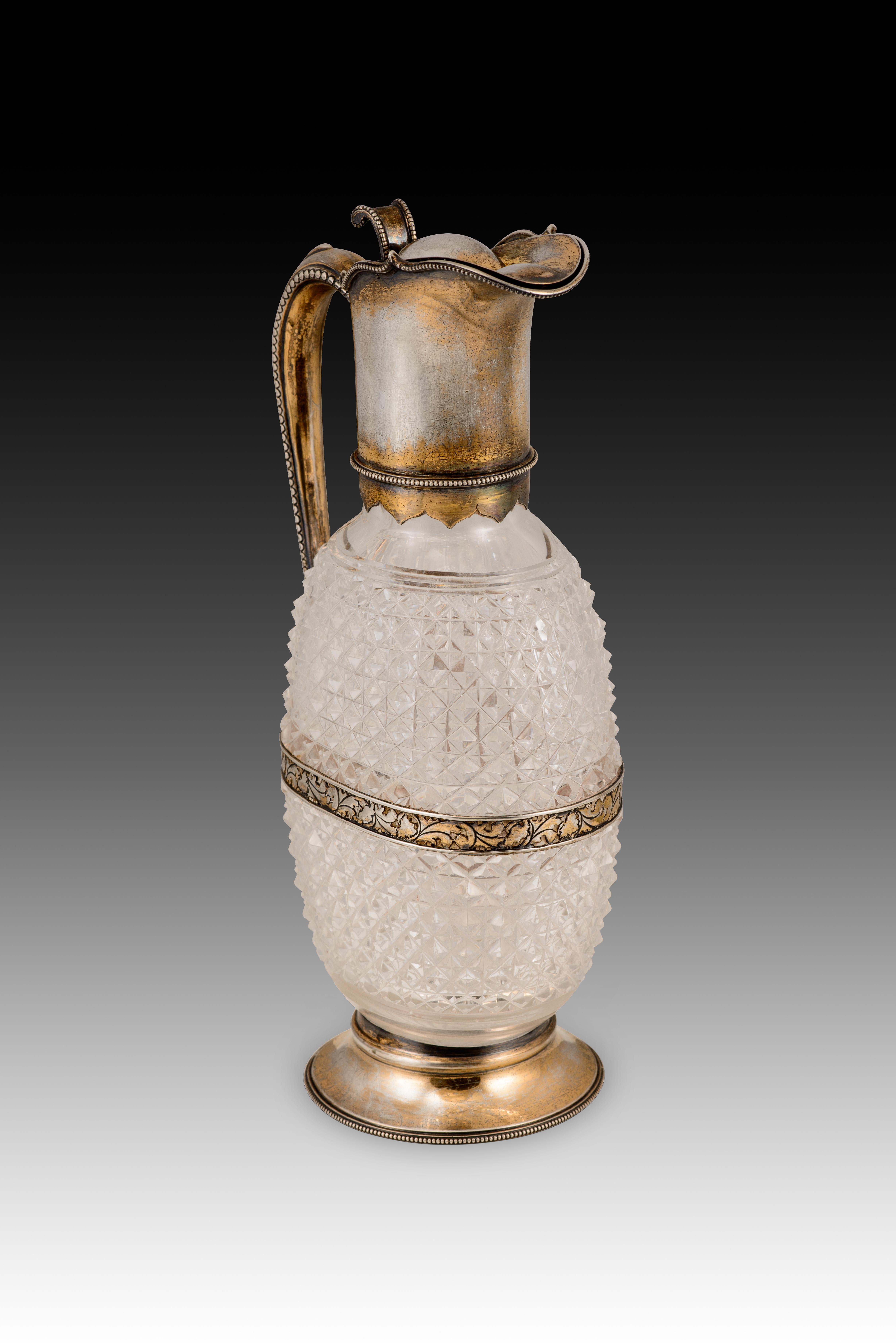 Pichet. Verre, Silver. Angleterre, Londres, Horace Woodward & Co Ltd, 1895. Leuchars & Son, Paris, France. 
Avec des marques de contraste. 
Une cruche en verre transparent ornée d'un cadre en argent (de couleur assortie à la dorure) et décorée de