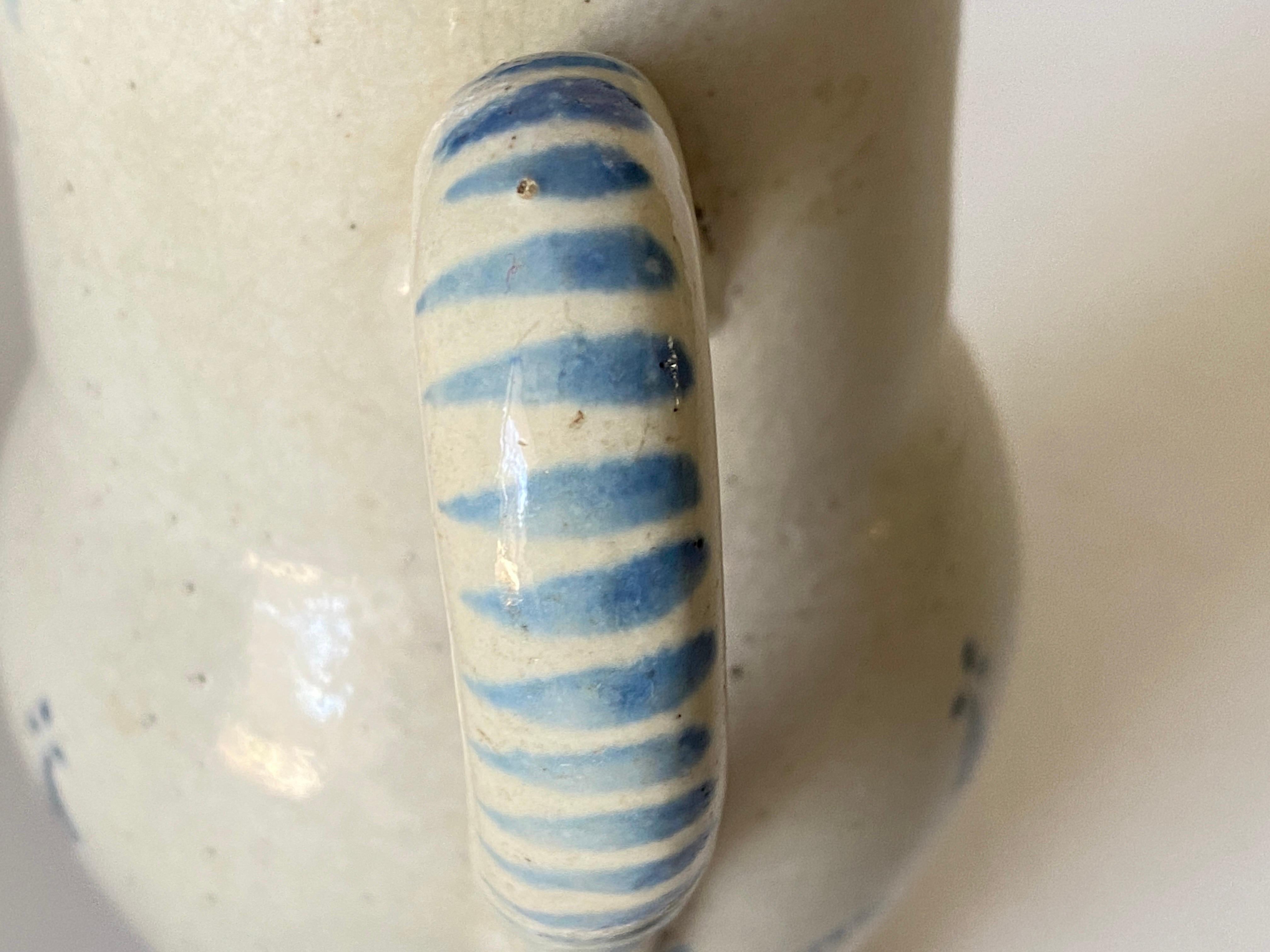 Cette cruche a une belle patine ancienne. Il provient de France et a été fabriqué au 18ème siècle. Le matériau est de la poterie et l'état est correct. Le décor est 