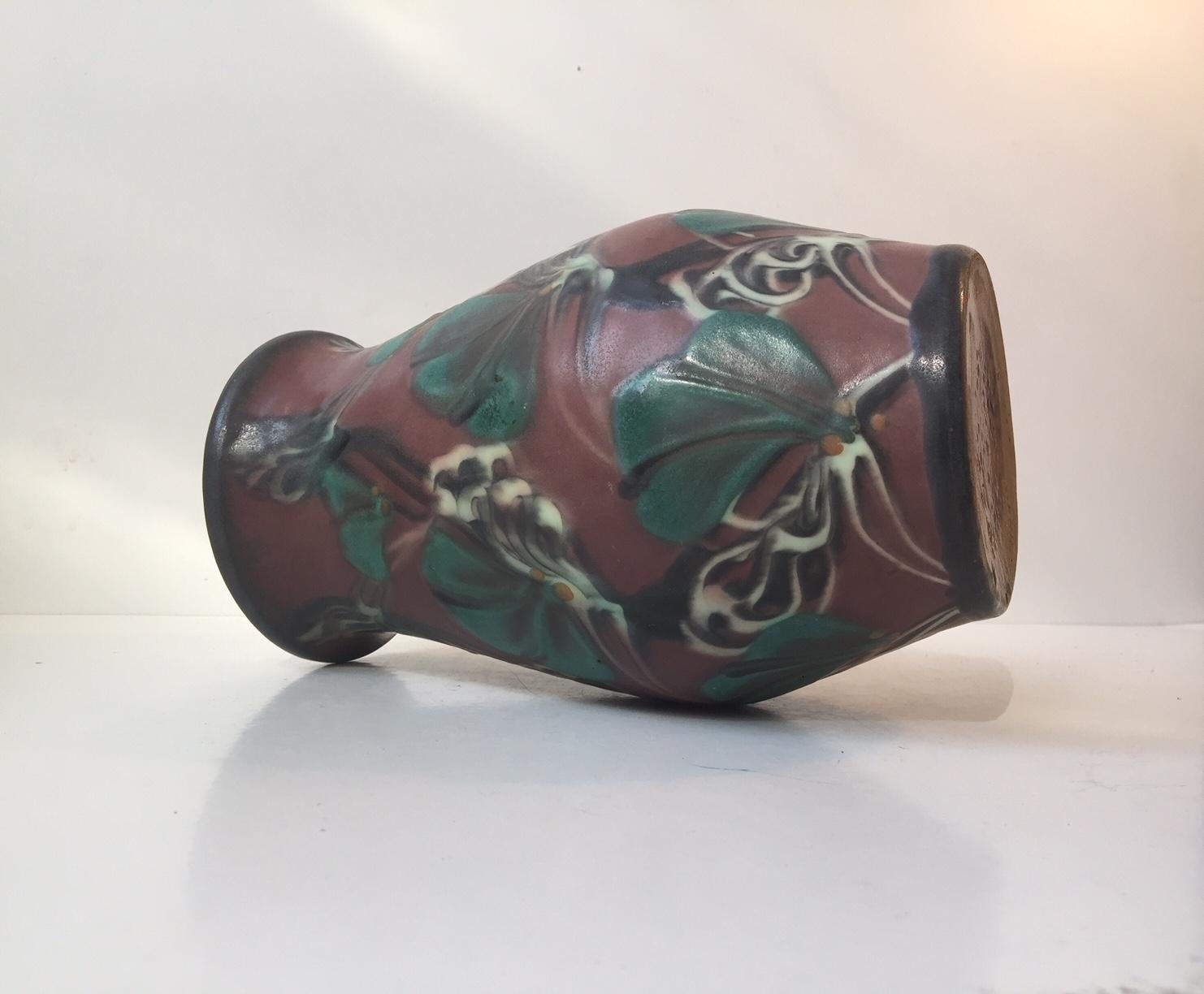This vase is in the Skønvirke style, which derives from the French Art Nouveau and German Jugend. The floral decorations on this vase were achieved by using slip trailed glaze through a cow horn and feather quill. Using this technique Danico went in