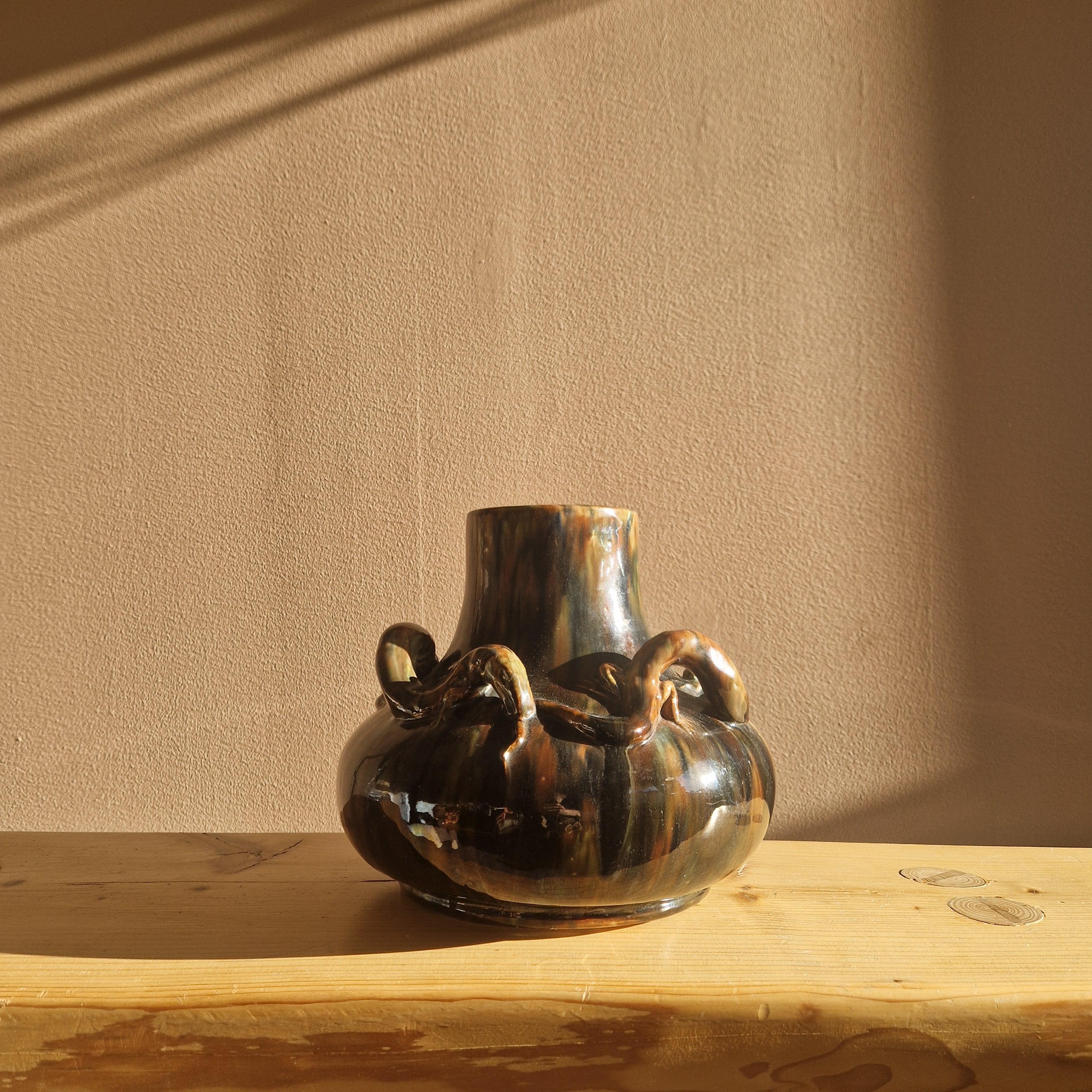A very rare decorative vase made by Karl Svensson for Höganäs, Sweden. Made in the early 20th century.
A large true Jugend ceramic vase glazed in mottled browns with specks of blue. Adorned with lizards in relief biting each others tails.
The vase