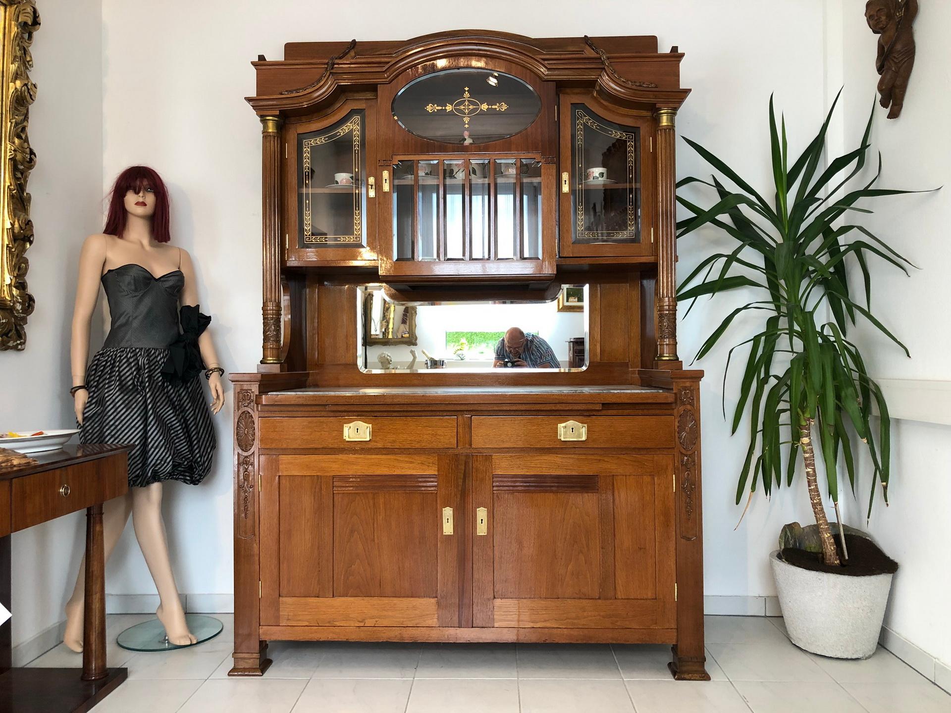 Extensively crafted Jugendstil buffet from Austria/ Vienna from the 1920s. Luxurious and unique piece made out of light oak wood and with plenty of crafted details. The lower commode offers storage space behind two doors and a wonderfully grained