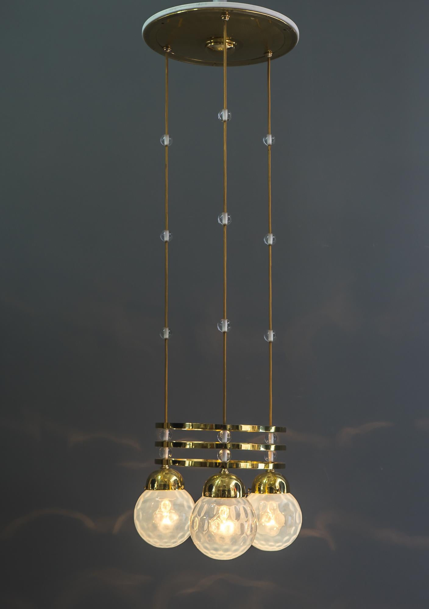 Jugendstil chandelier Vienna around 1903 with original loetz witwe glass shades
Executed by Bakalowits and Söhne
Polished and stove ennameled brass parts
New wired
Solid glass balls on wire 
We can adjust the height to the height of the room.