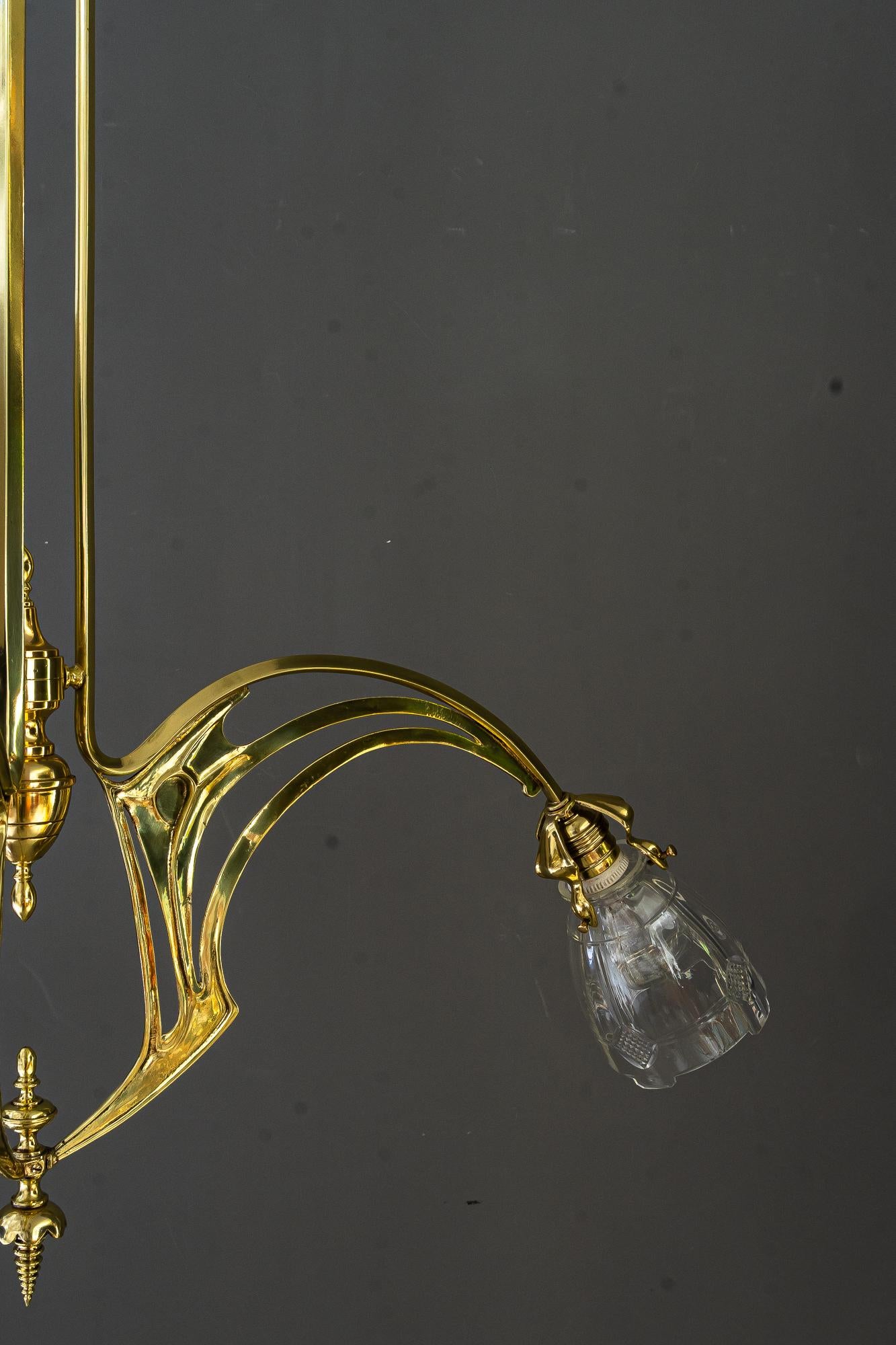 Jugendstil-Kronleuchter im Jugendstil mit originalen geschliffenen Glasschirmen Vienna um 1910
Messing poliert und emailliert
Original antike geschliffene Glasschirme