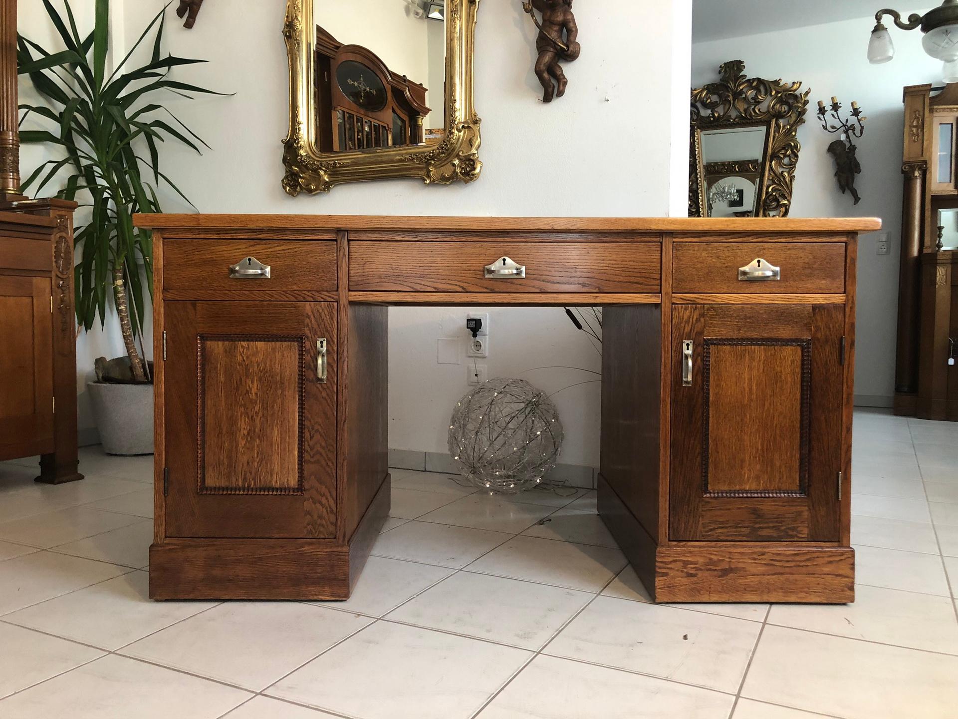 Beautiful Jugendstil desk made out of solid oakwood with a beautiful green fabric tabletop. The 1910s piece features three drawers and two doors for storage considerations. On the interior, you can find a shelve as well as three additional drawers