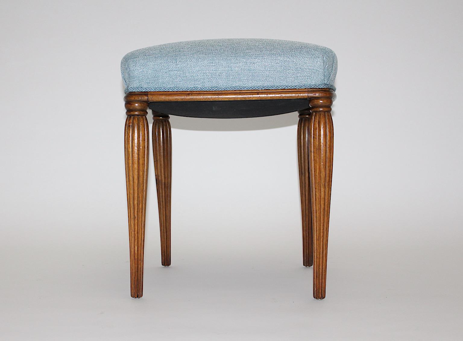 Jugendstil vintage stool from walnut with blue upholstery design attributed to Otto Prutscher circa 1900 Vienna.
This beautiful stool features solid walnut feet with grooved and fluted shape while the stool shows an elegant effect. With walnut feet