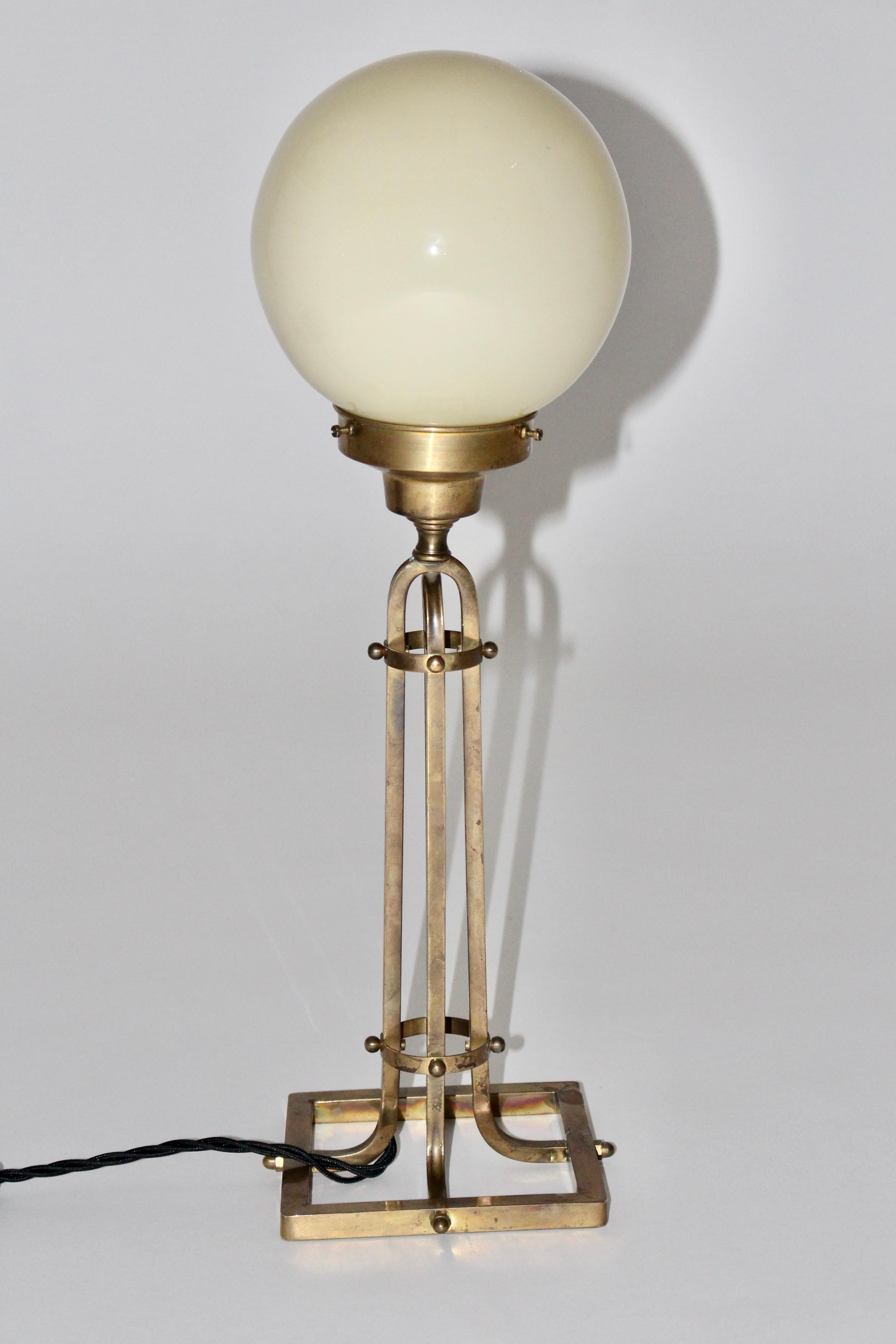 Lampada da tavolo in stile Jugendstil Secession in ottone e vetro anni '50, Austria.
Un'affascinante lampada da tavolo molto simile allo Jugendstil con una struttura geometrica in ottone e un paralume a sfera in vetro color avorio.
La struttura in
