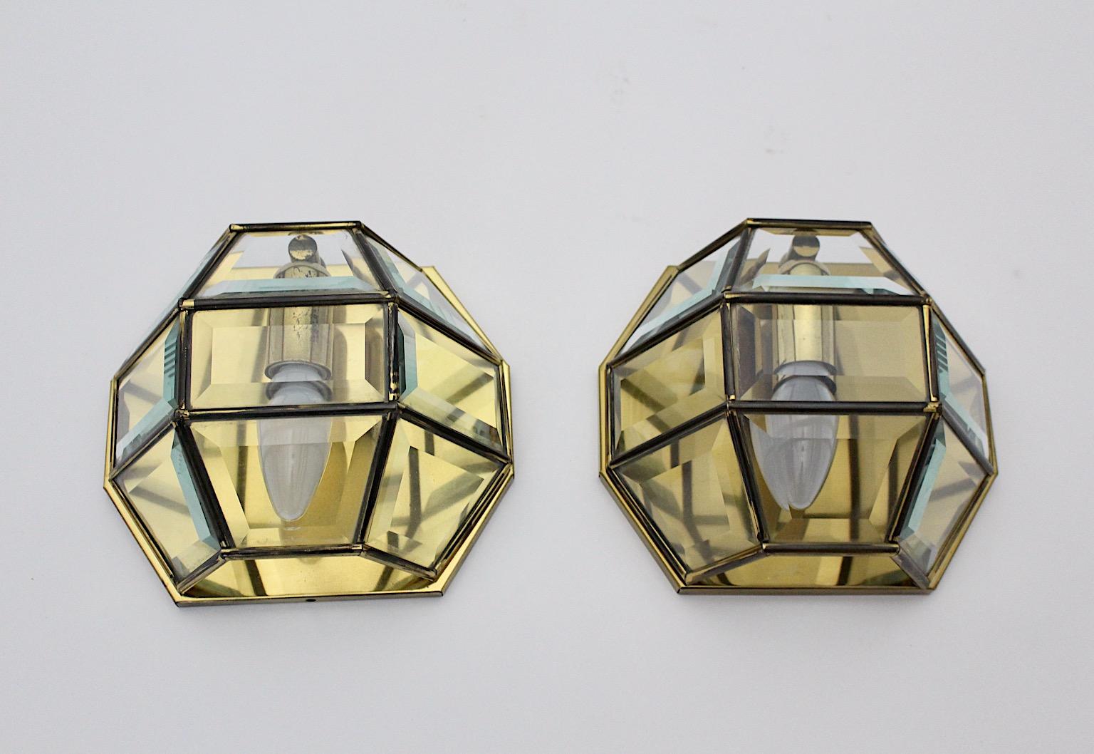 Adolf Loos style vintage Jugendstil style sconces or wall lights pair duo from well patinated brass and facetted clear glass 1970s Austria.
The stunning pair of sconces shows facetted clear glass and solid brass frame with beautiful patina.
Each