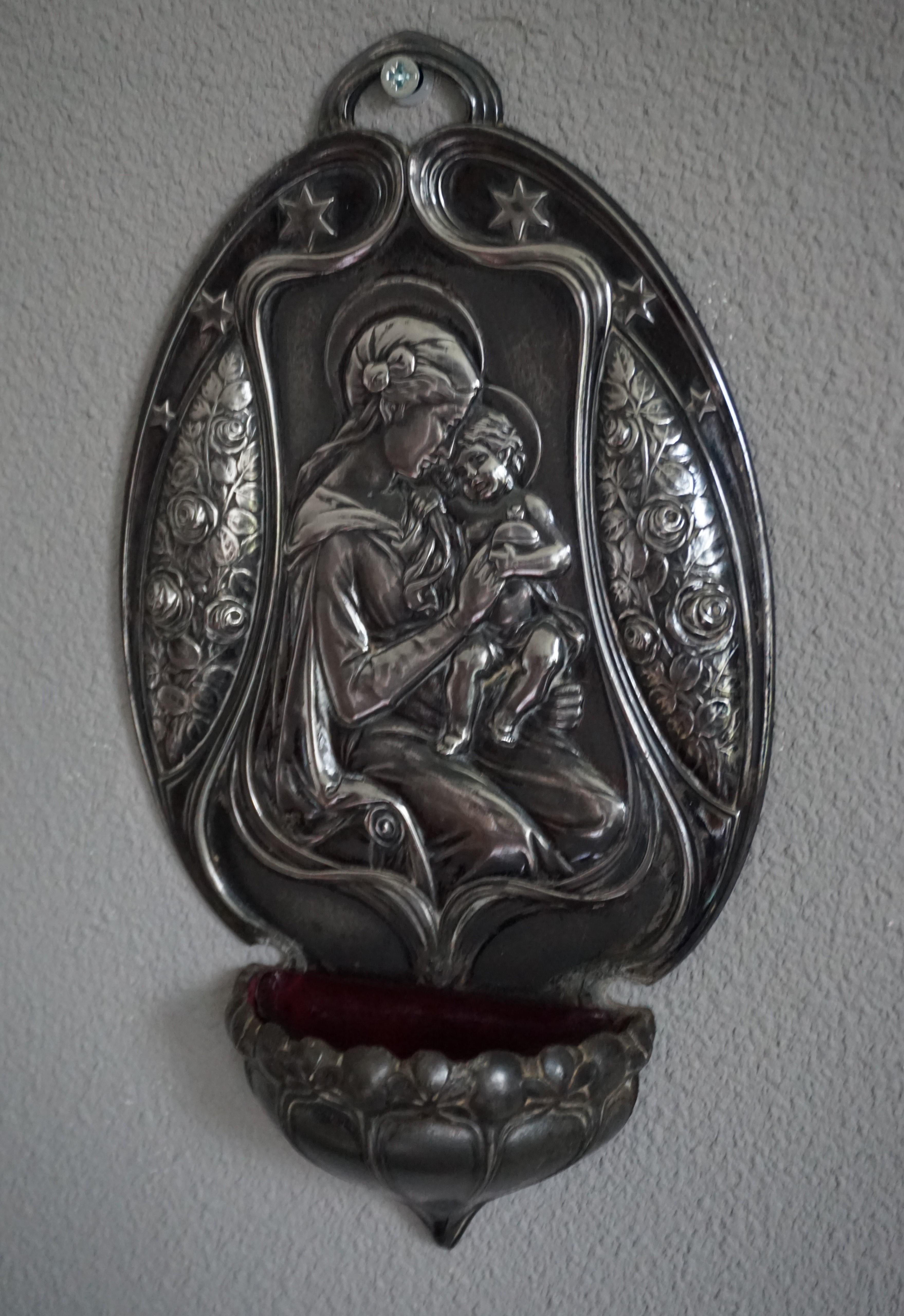 Antique silvered wall font with original and excellent condition glass vessel.

This rare Jugendstil wall font by German makers WMF is in excellent condition and it even comes with the original glass vessel. To make the marvelous image of Mary and