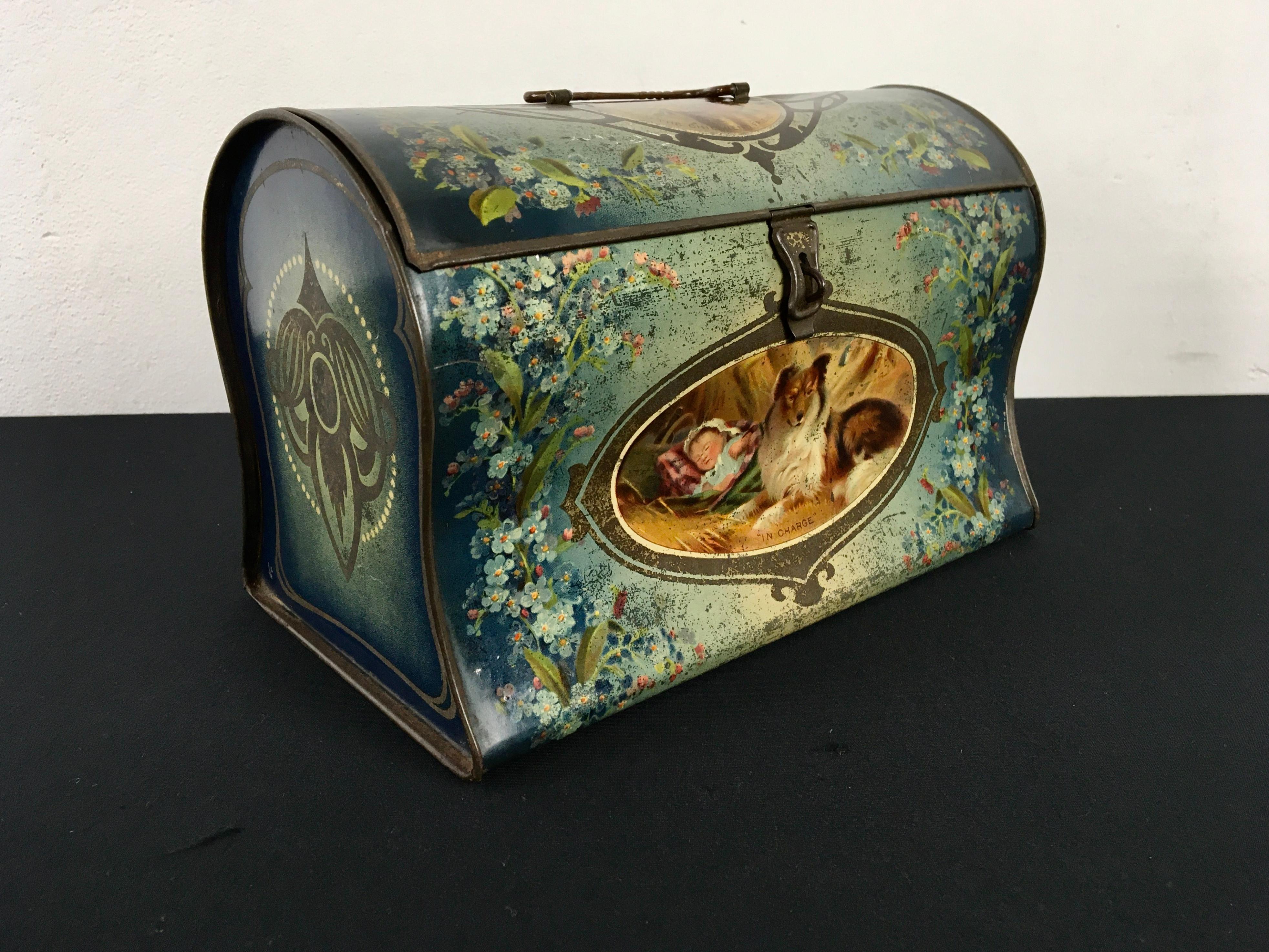 Jugendstill - Art Nouveau tin with handle and Dogs. 
You see a Collie dog known as Lassie 
and St Bernard Dog or Saint Bernard Dog.
It's a beautiful shaped tin with an unusual design: it looks like a suitcase, handbag or bag to hold. Blue