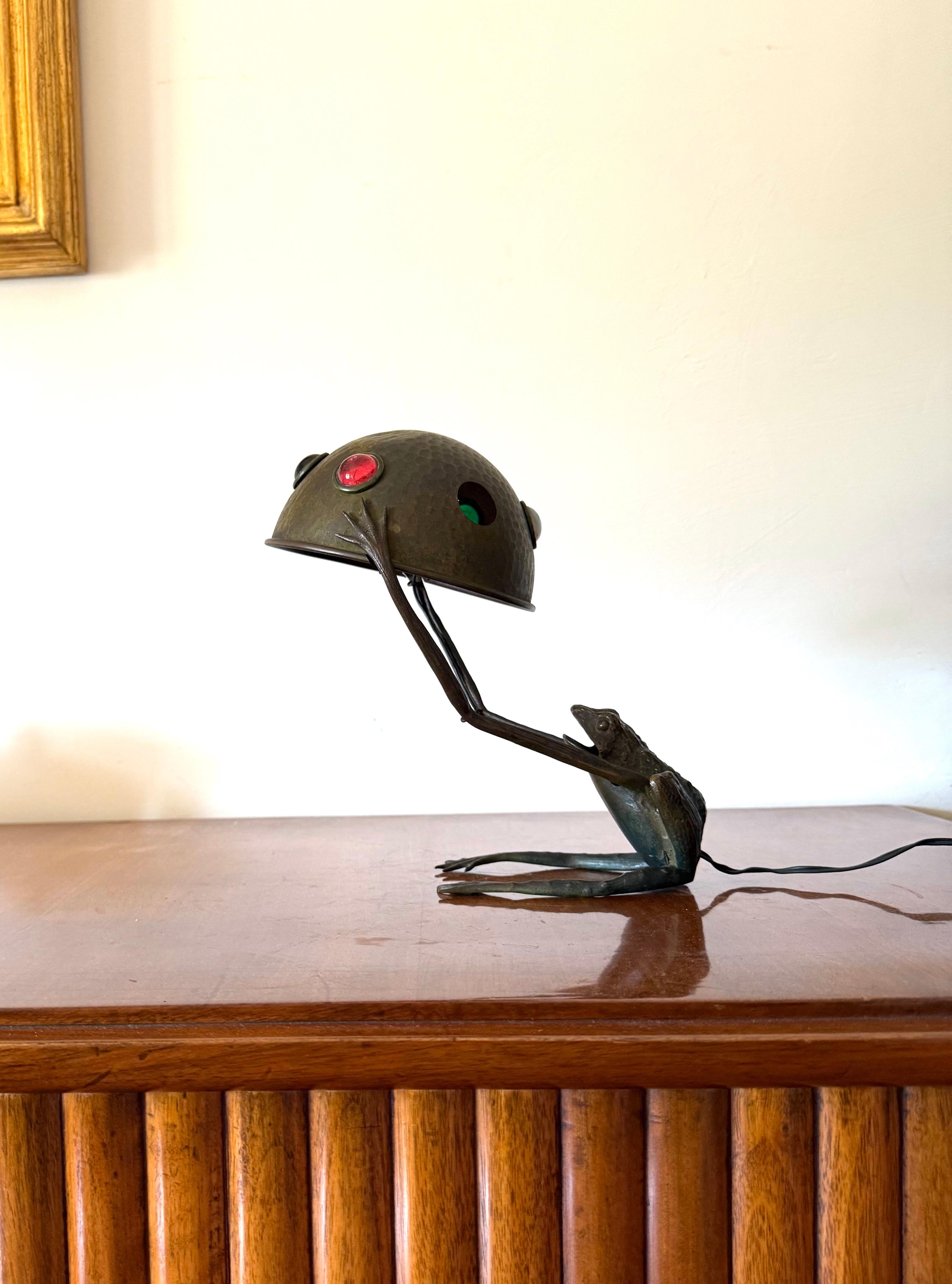 Jugenstil rare frog shaped bronze lamp

Austria 1900s ca.

Patinated bronze naturalistic frog-shaped base, hammered brass cap with polychrome cabochon inserts

H 25 cm × 24 cm × 17 cm

Conditions: good consistent with age and use. Two missing