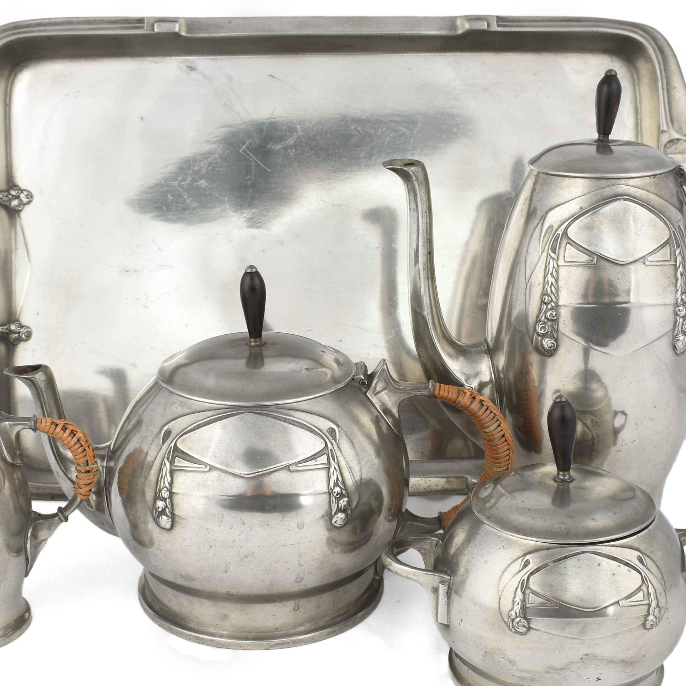 Jugendstil Centerpiece on Tray is a vintage decorative object realized in the 1905/1910.

The lot includes: one coffee pot, one tea pot, one cream server, one sugar bowl and one rectangular tray.

All the pieces are realized in silver plate. 

Made