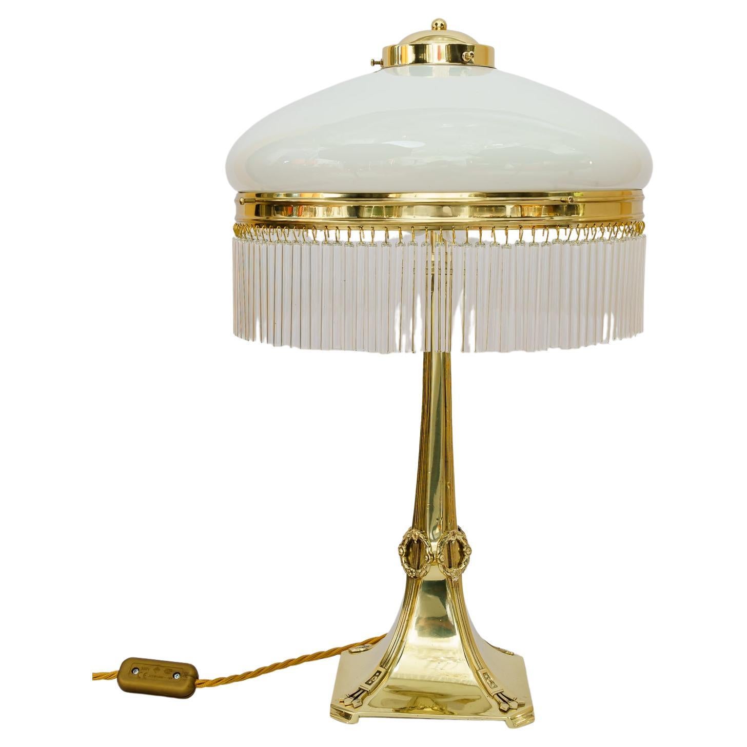 Jugenstil table lamp Vienna around 1910s.
Brass polished and stove enamelled.
Opal glass shade.
Glass sticks are replaced (new).