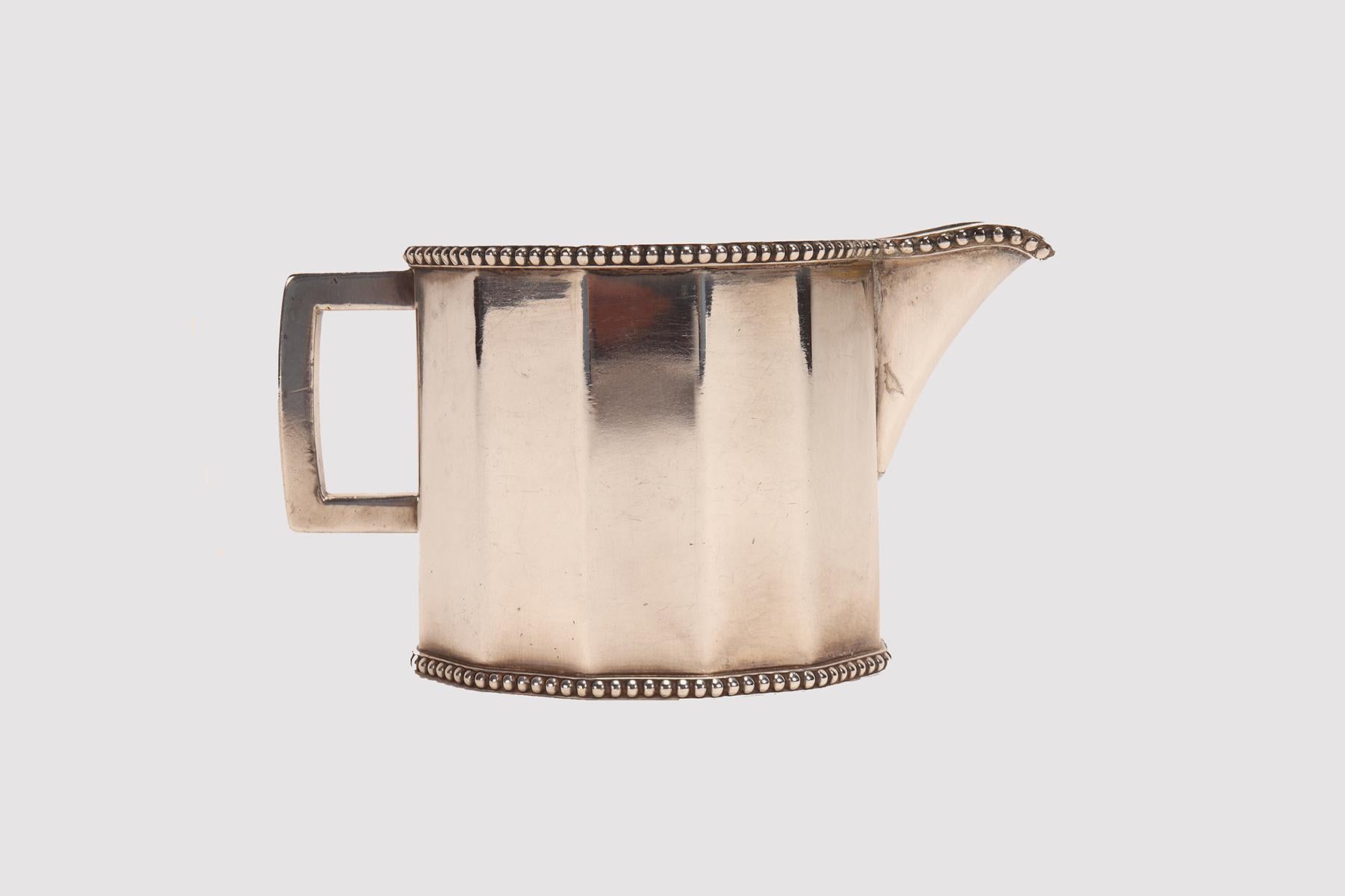 A Jugenstill milk jug with handle, made of dodecagon-shaped smooth silver-plated brass.
Wiener Werkstätte, Vienna, Austria circa 1920.
