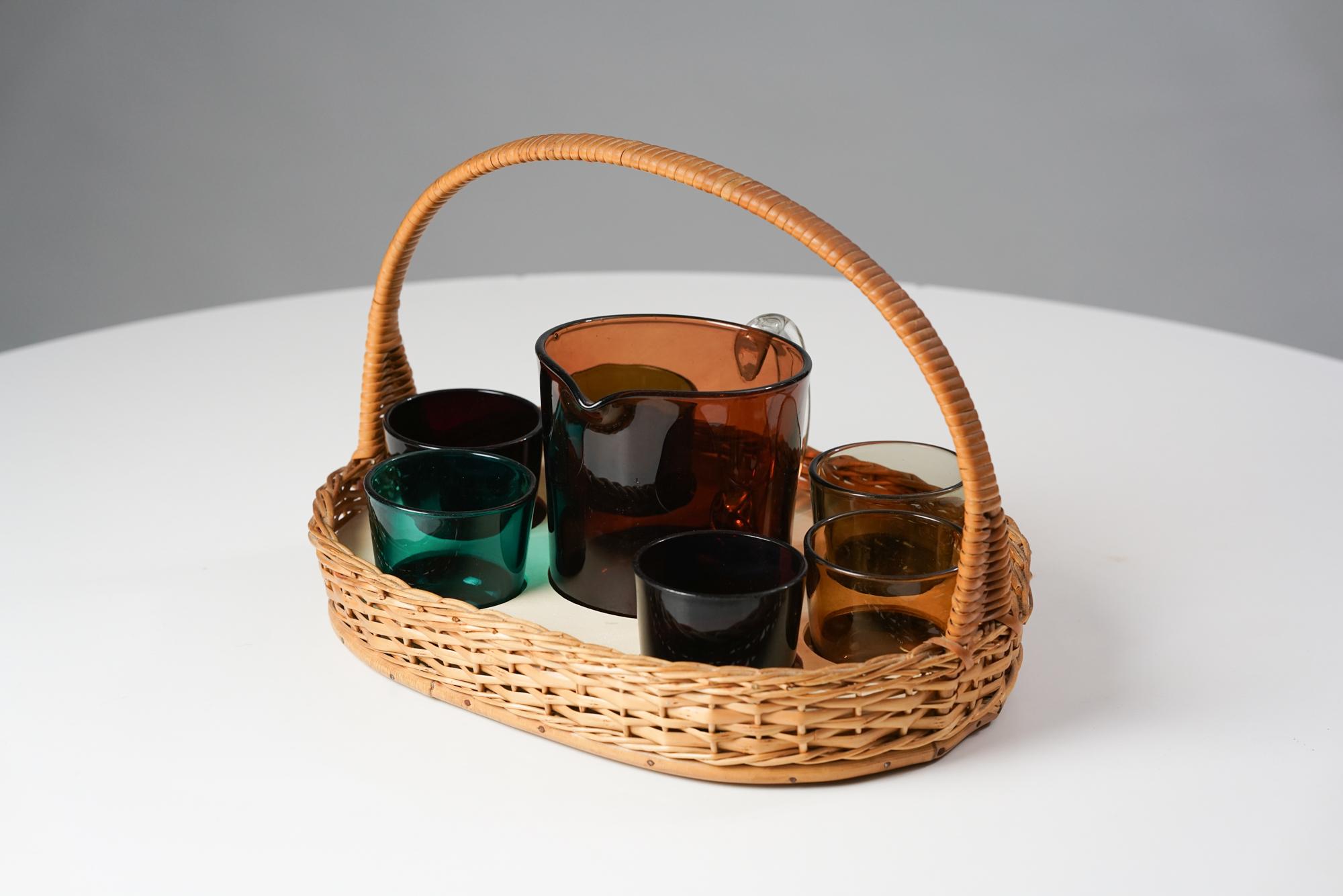 Juice-Set von Kaj Franck für Nuutajärvi Notsjö aus den 1950er Jahren. Entworfen im Jahr 1954. Das Set besteht aus einem Weidenkorb mit rattanumwickeltem Griff, sechs Gläsern und einer Vase. Verschiedene Farben auf den Gläsern. Guter Vintage-Zustand,