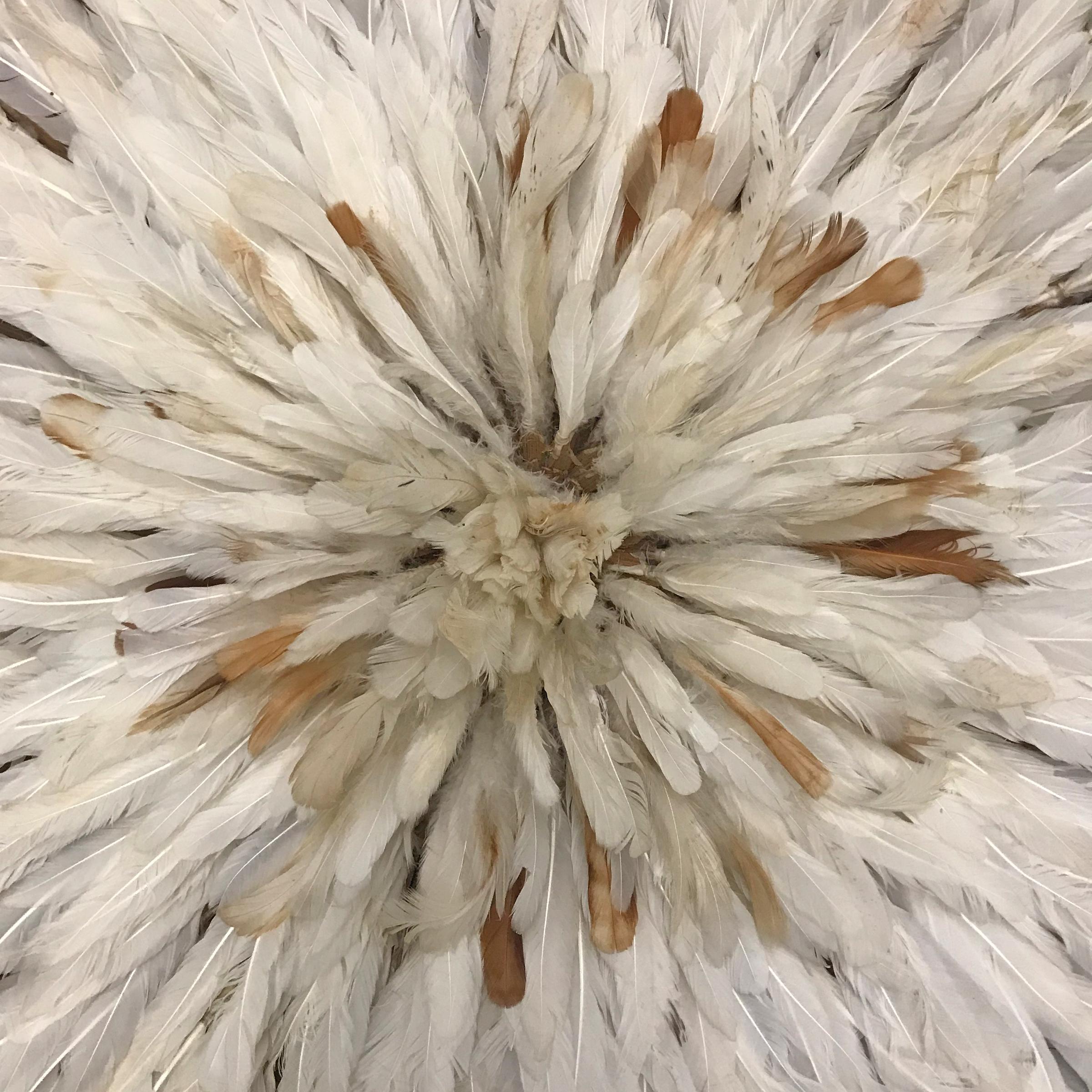 A fantastic late 20th century Bamileke Juju headdress created by weaving a foundation of plant fibers, and filled with hundreds of white and brown chicken feathers. The headdress folds up for storage. Juju headdresses are handmade by the Bamileke