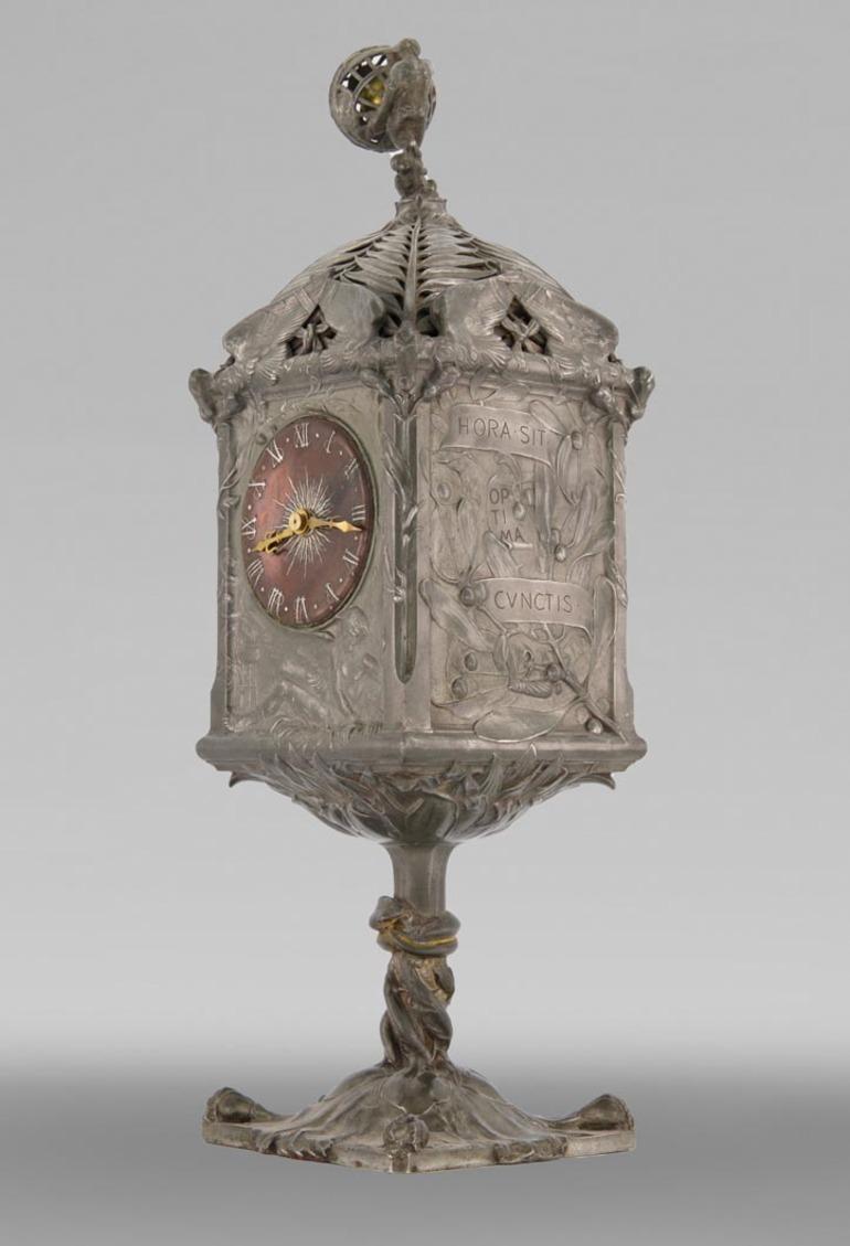 Made in 1900, our clock is a major work by sculptor and goldsmith Jules Brateau. This renowned craftsman won several medals at world's fairs.

Jules Paul Brateau (1844-1923) was a goldsmith, jeweller and pewter potter. He studied at the École