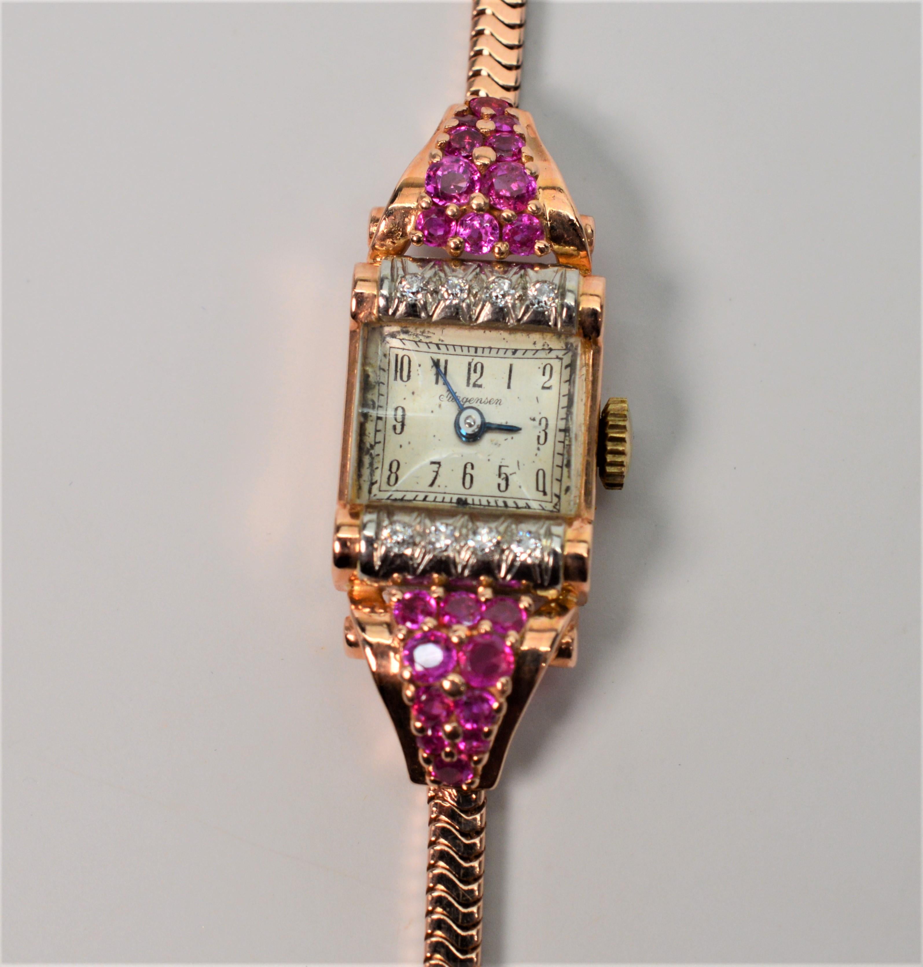 Circa 1950 Ladies 14 Karat Yellow Gold Bracelet Wrist Watch. The square face is flanked with .12 carats Diamonds total weight and .32 carats Rubies total weight. Movement is 17 Jewel JxJ. In working condition, this ultra feminine Jurgensen measures