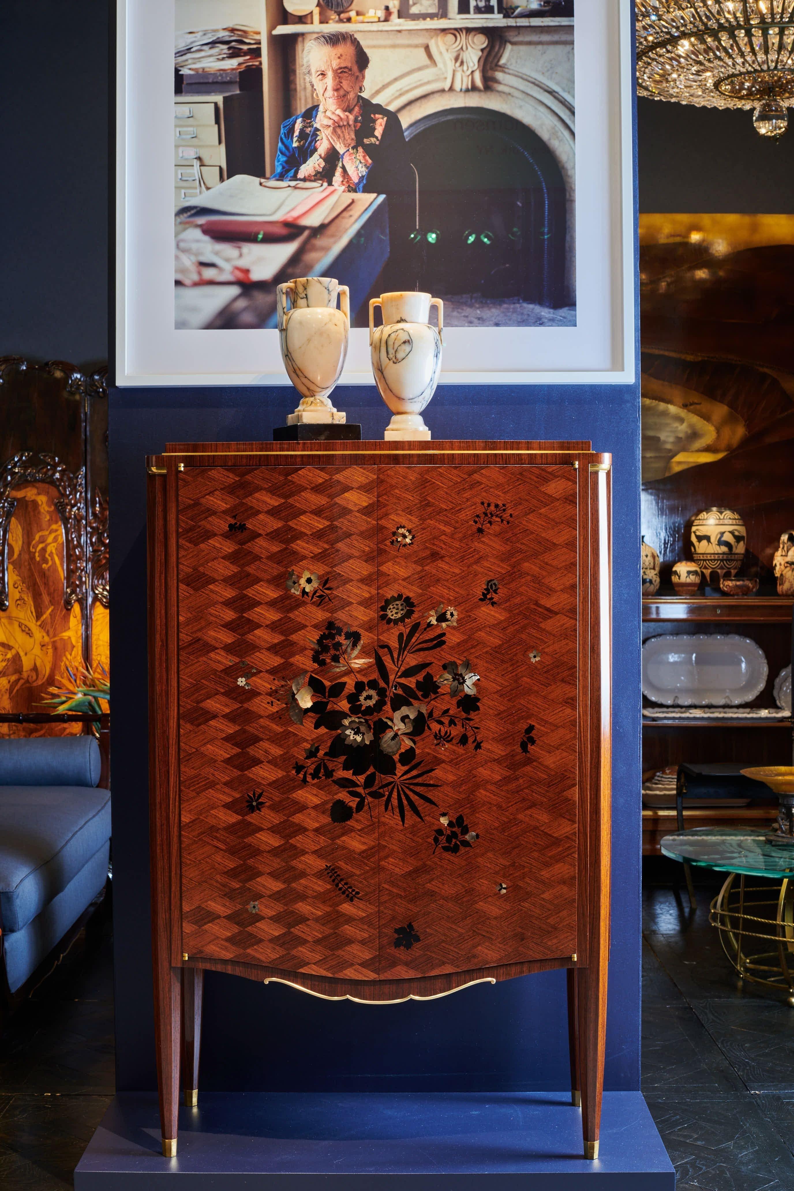 This exceptional matched pair of two door cabinets was made in the aftermath of the war, a time when Jules Leleu was returning to the Deco splendor of plush, exotic materials. This particular piece, with its marquetry, gilt bronze details, and