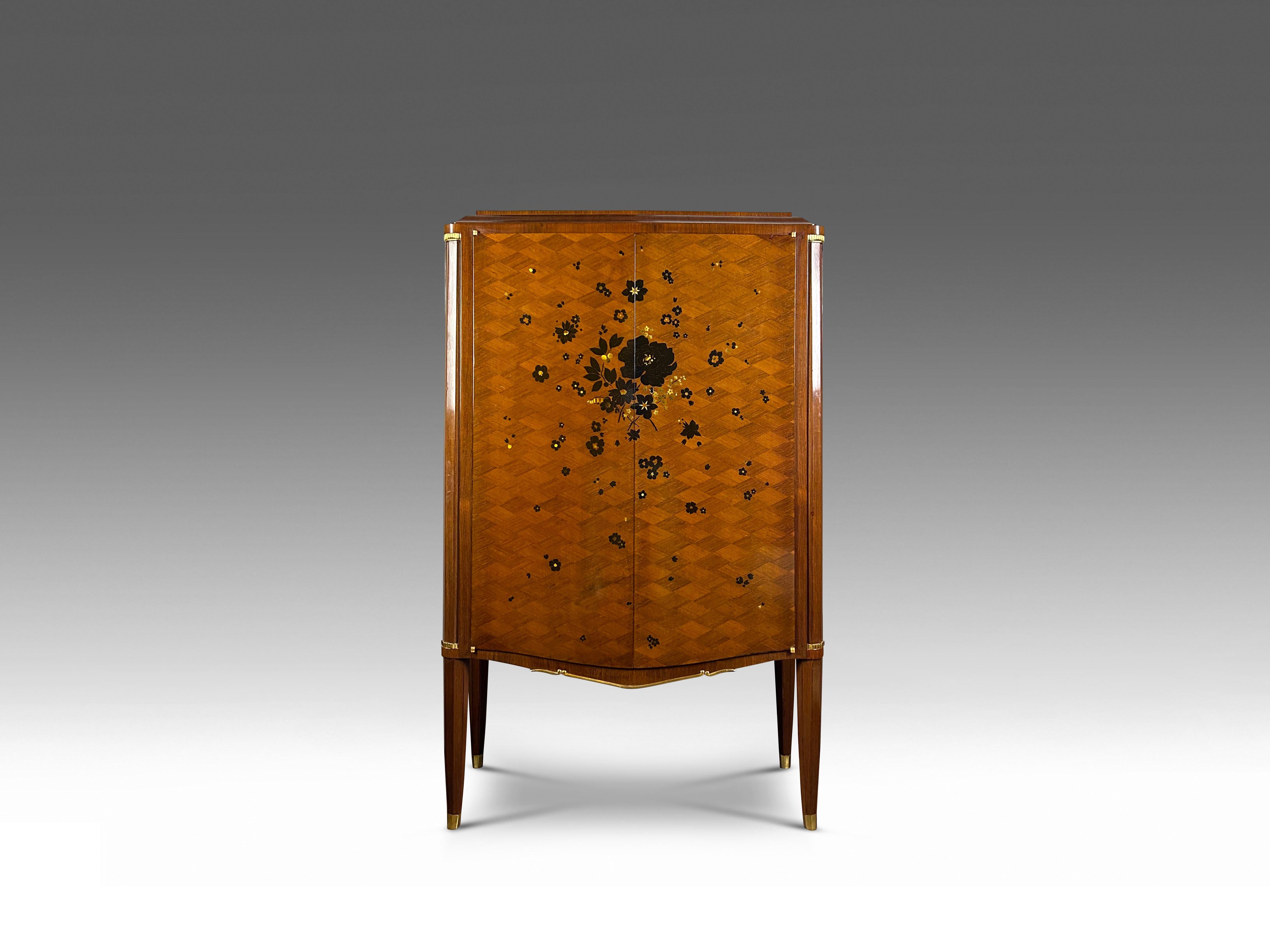 A truly exceptional rare and refined cabinet from the late Art Deco period by one of the most renowned French furniture designers of this period, Jules Leleu. The two gently bowed doors are richly adorned with a spray of wild flowers executed in