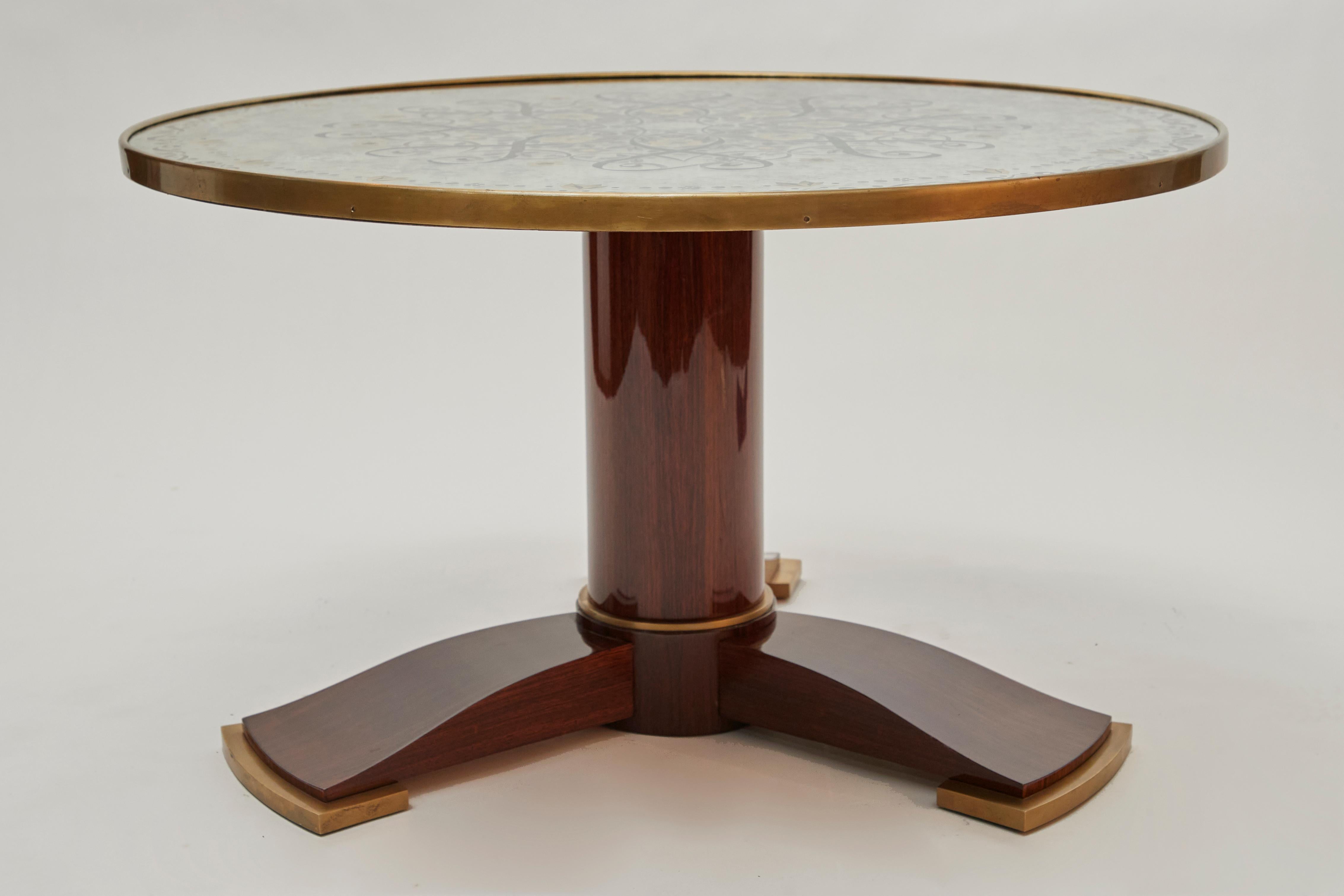 This extraordinary table, designed by one of the early 20th century's greatest designers, represents the consummation of French Art Deco elegance. The table's circular top--a spectacular work of verre eglomise set like a jewel in a frame of gilt