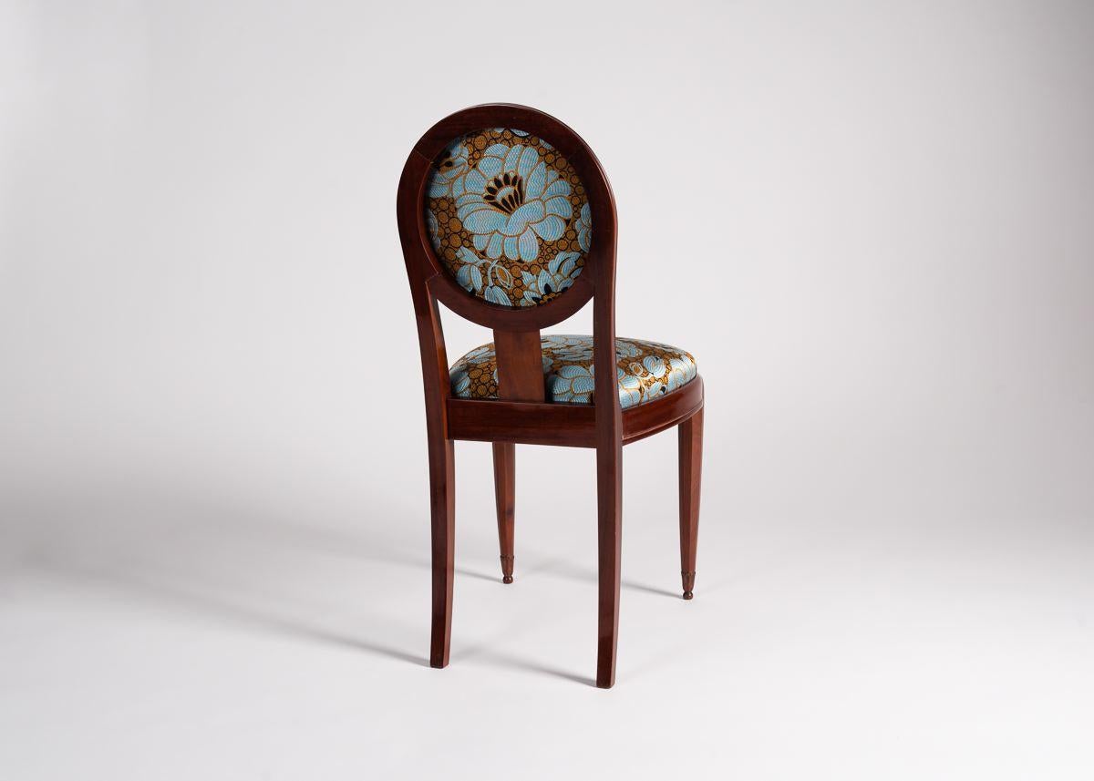 A lacquered walnut side chair designed by Jules Leleu with an elegant, tall back covered in a round upholstered cushion, and beautifully carved, tapered legs.