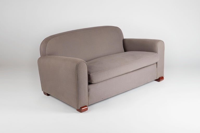 A lush, upholstered sofa with rounded arms, back, and feet. These last, executed in French polished beech, serve as a charming, subtle accent.

Numbered: P25137

For an illustration of a similar model, see Mobilier et De´coration, no. 5. 1946.