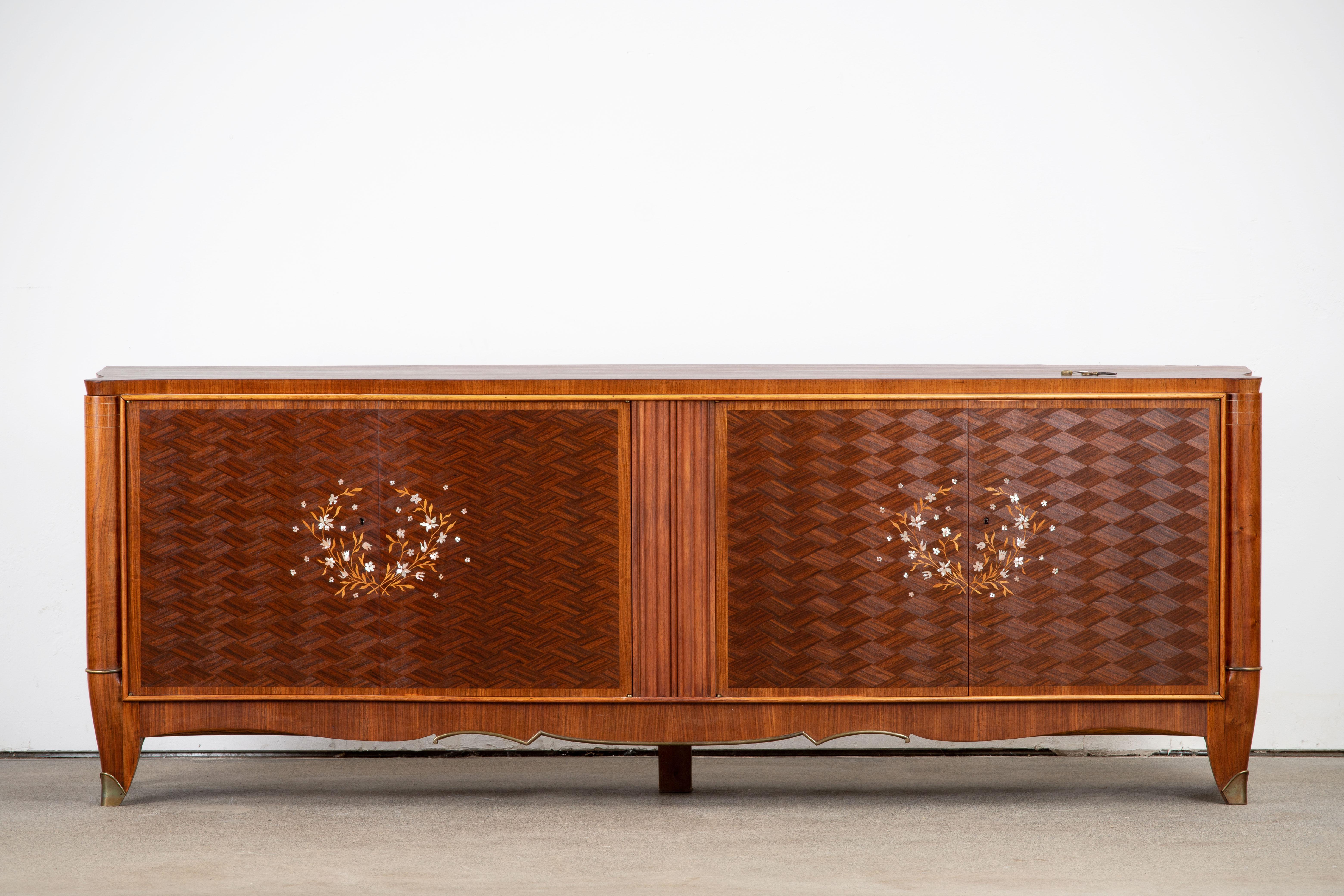 This French Art Deco sideboard, credenza was found in a little Castle in Normandy; France. The sideboard features stunning Macassar ebony wood grain with a thin decorative mother of pearl inlay design with butterflies and birds. The inside is also a