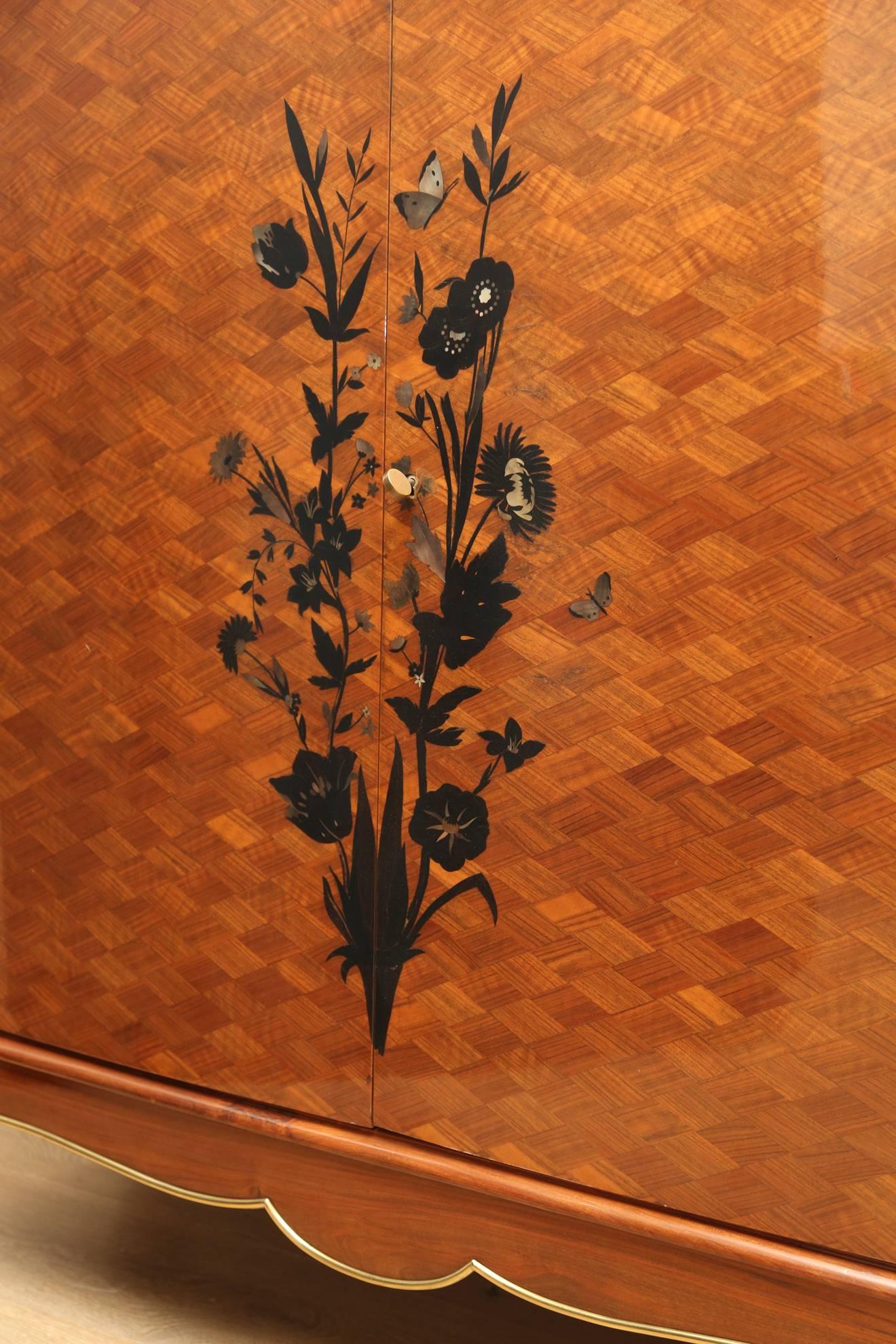 French Art Deco cabinet by Jules Leleu. Fine marquetry work with mother-of-pearl flowers and butterflies, polished bronze linings, legs with gilded bronze sabots. Portoro marble.