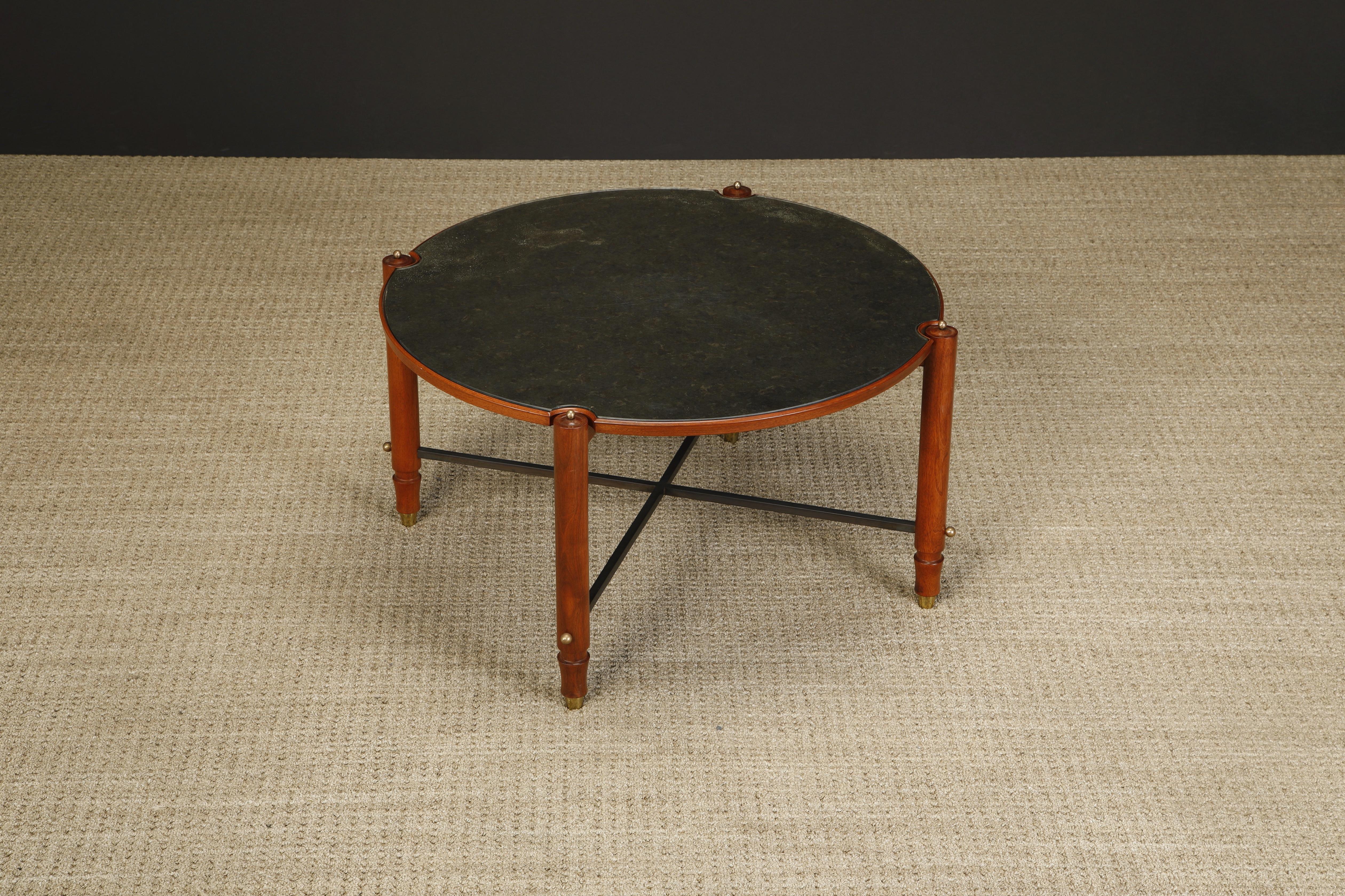 Cette table basse exquise de Jules Leleu a été exécutée en France vers 1957. Elle est en acajou avec des châssis en métal patiné, des accents en laiton et un plateau en verre miroité antiquité. Documentée dans Leleu Decorateurs Ensembliers par