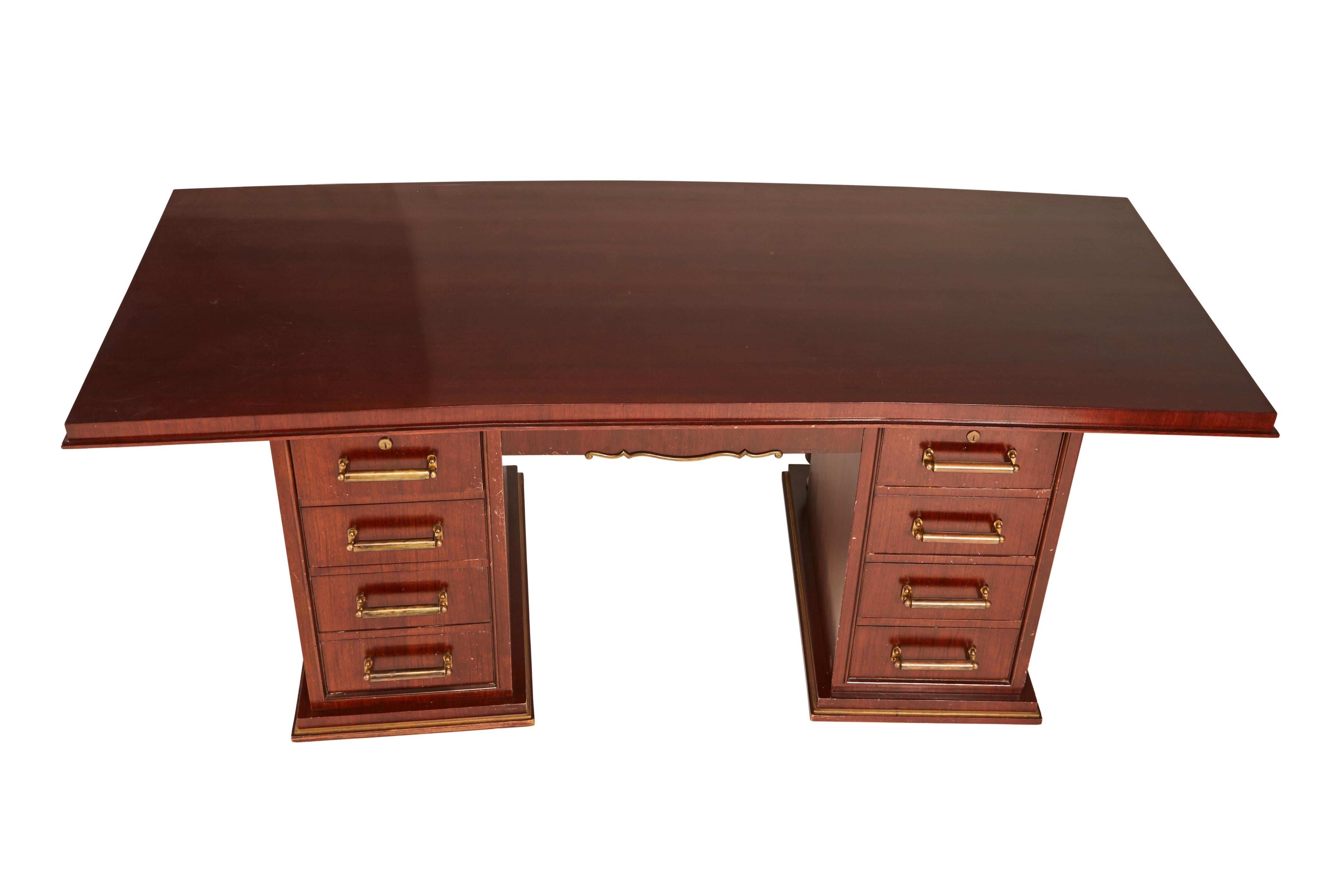 Jules Leleu (1883-1961) double-fronted mahogany and brass desk, circa 1935.
Having two set of four pedestal drawers and a single frieze drawer, accented in gilt bronze. Inset with plaque J. Leleu.... no key.
Wear to finish on top and drawers, to