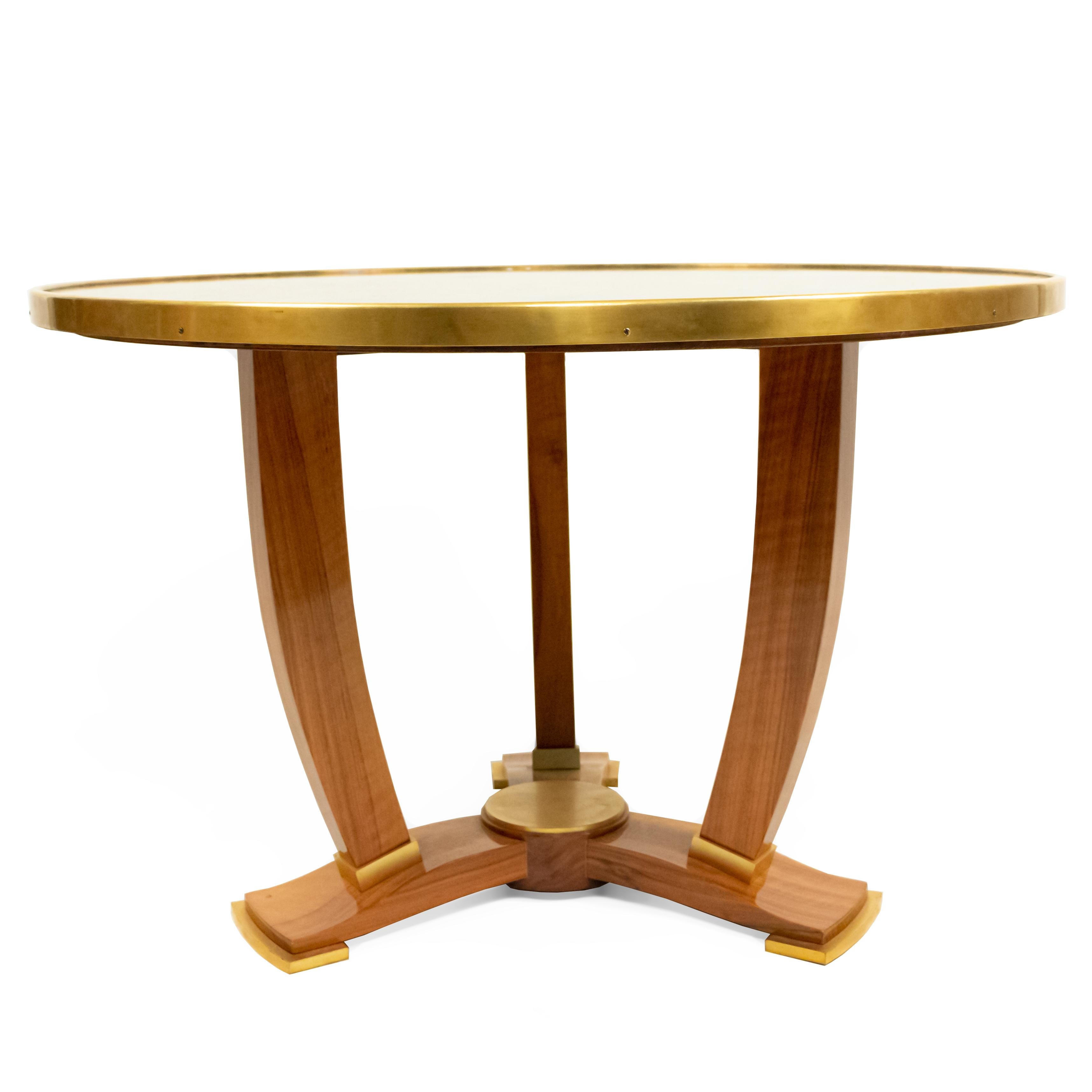 French midcentury round gilt metal coffee/side table with an inset verre églomisé top having a vegetable design resting on three curved feet ending in gilt bronze sabots (Jules Leleu ca. 1950).
