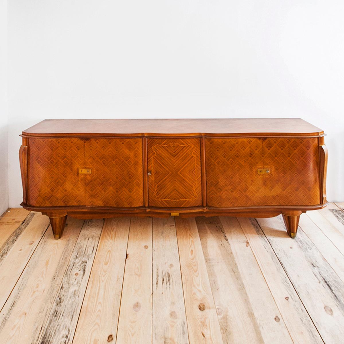 Jules Leleu French rosewood diamond Marquetry Art Deco sideboard, 1940's

This French Art Deco sideboard originates from the 1940s, It was produced by Maison Jules Leleu and is made from rosewood and mahogany. It has five doors, the central one