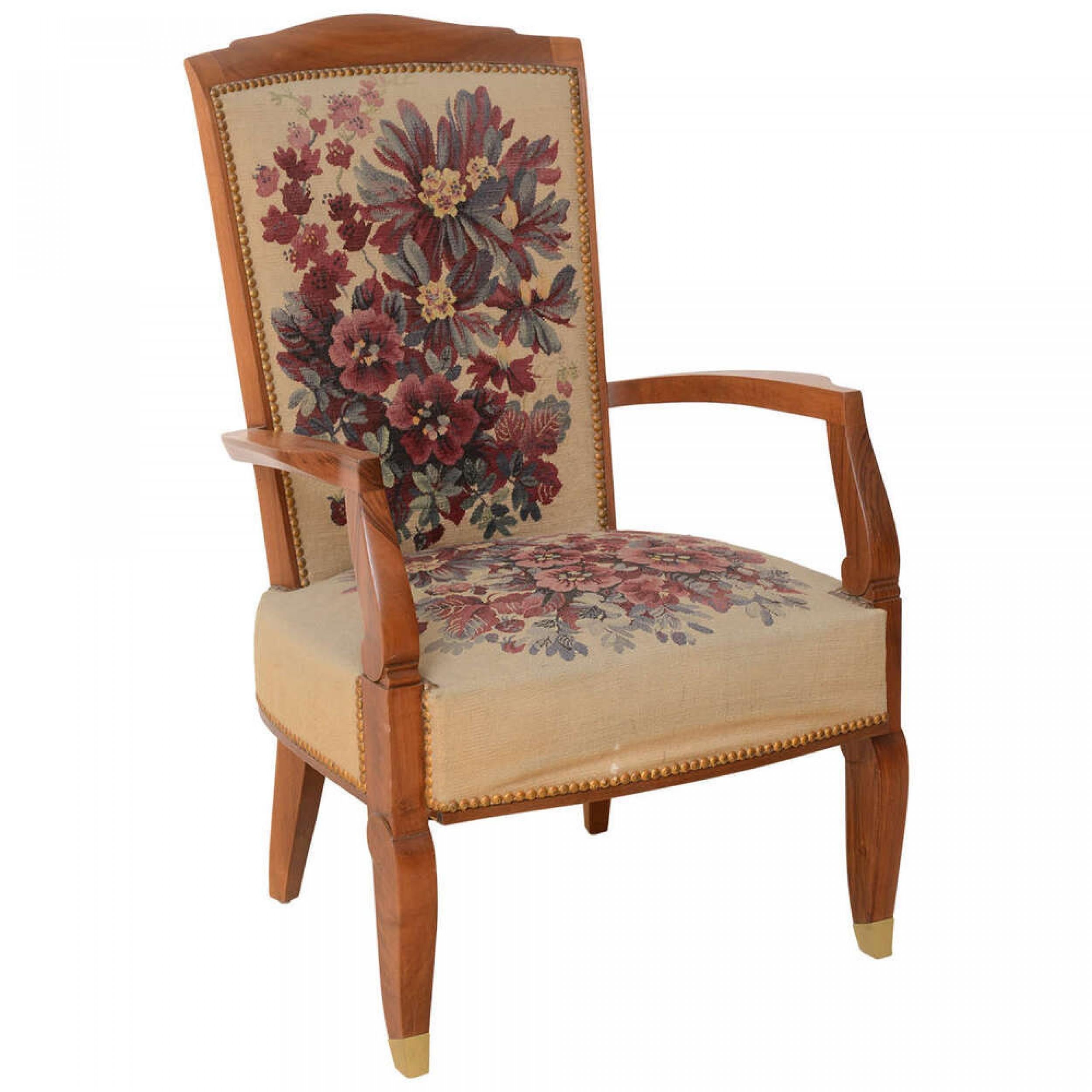 Late Art Deco mahogany open armchair with floral tapestry upholstery, resting on two shaped front legs ending in brass sabots and 2 splayed back legs. (JULES LELEU).